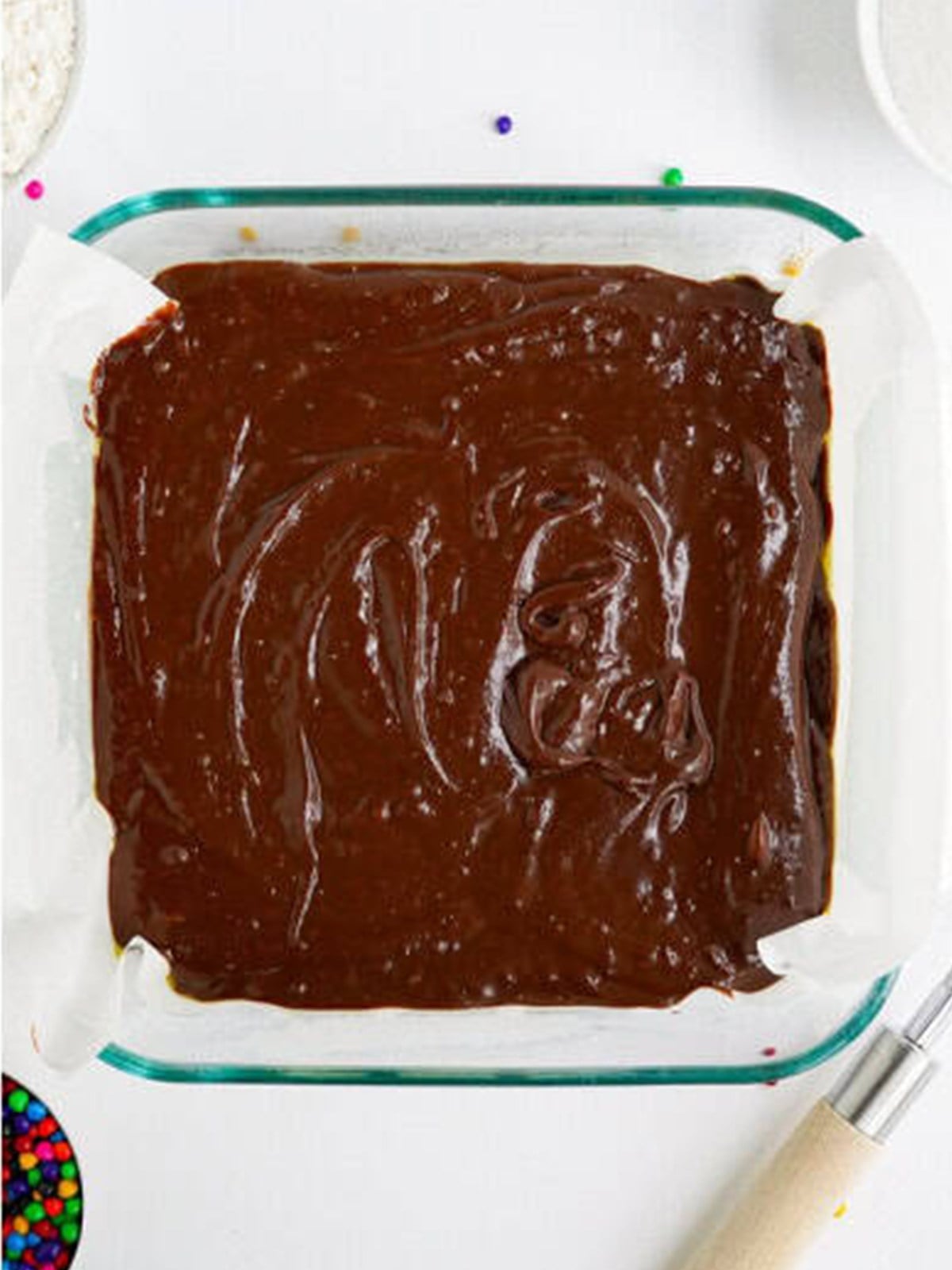 Cosmic brownie batter spread evenly into a parchment lined baking pan.