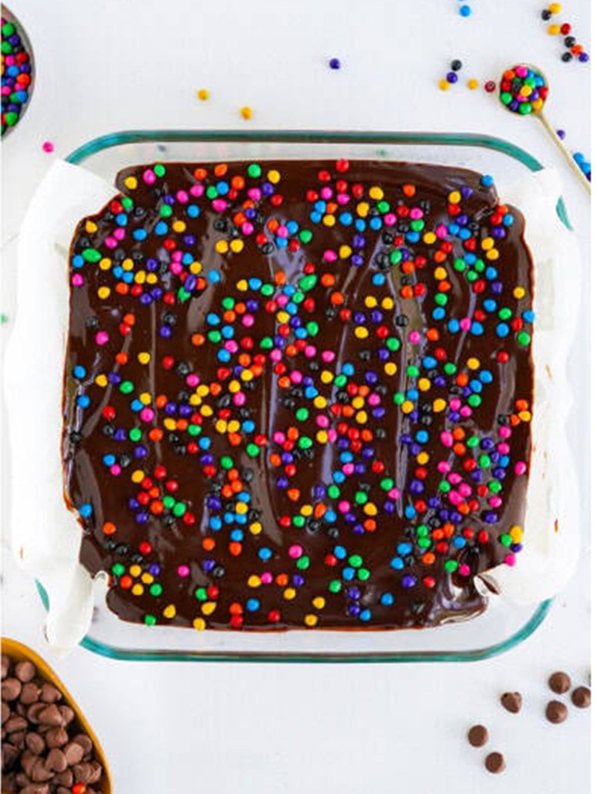 Rainbow chip sprinkles scattered over the ganache topped cosmic brownies.
