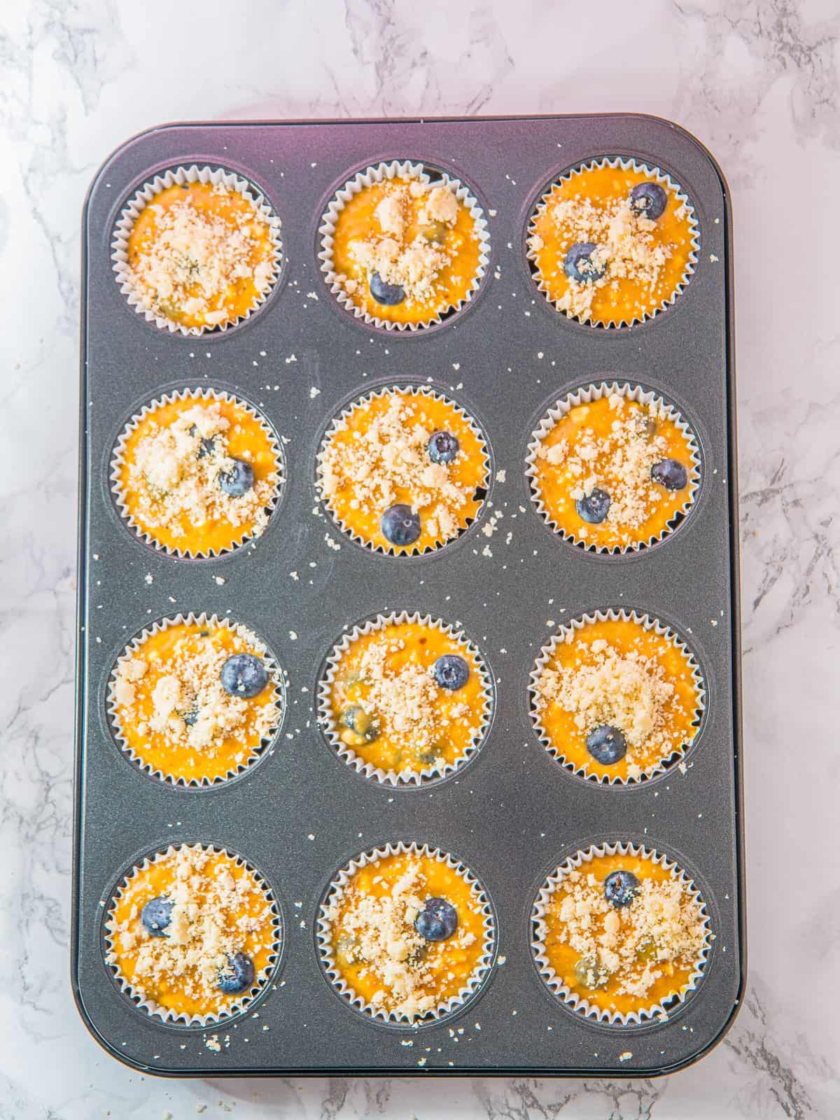 Streusel topping sprinkled over the muffins for Cottage Cheese Blueberry Muffins.
