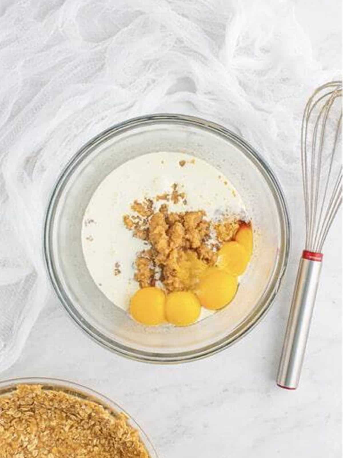 Adding heavy cream, egg yolks, and vanilla to the crack pie filling.