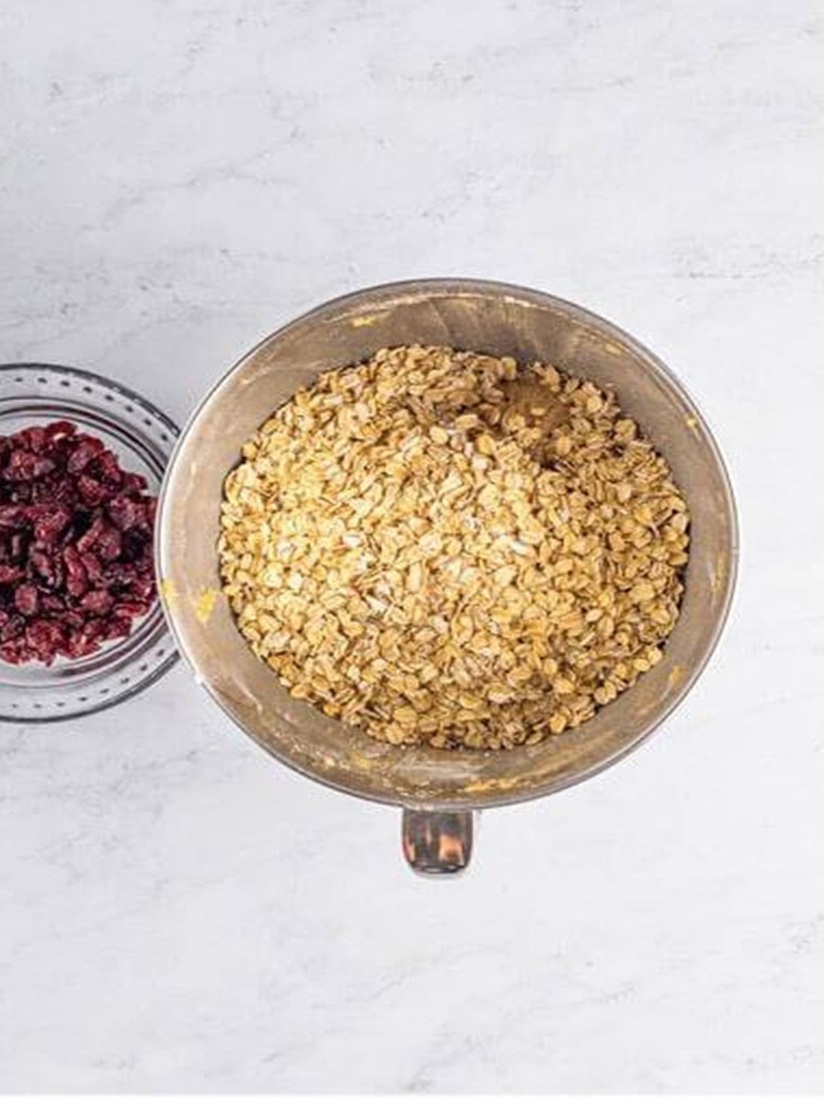 Oats added to the cookie dough in a mixing bowl.