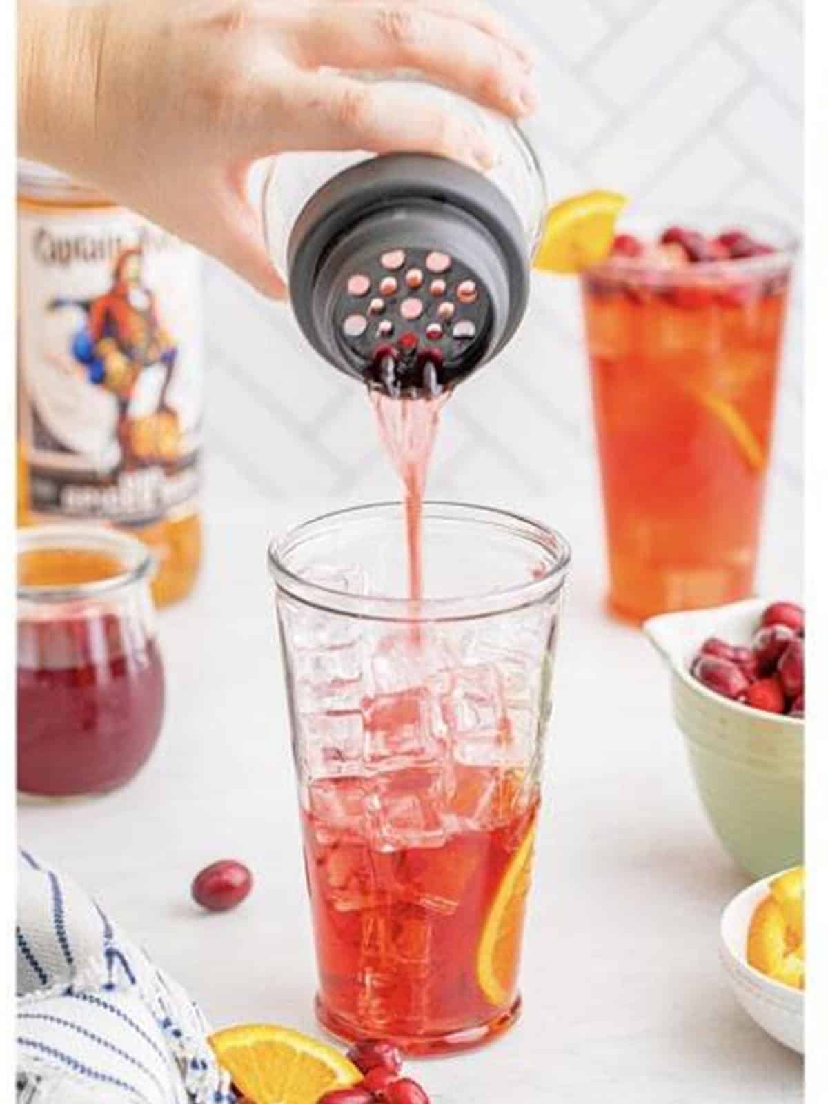 The cranberry rum mixture strained over a tall glass of ice.