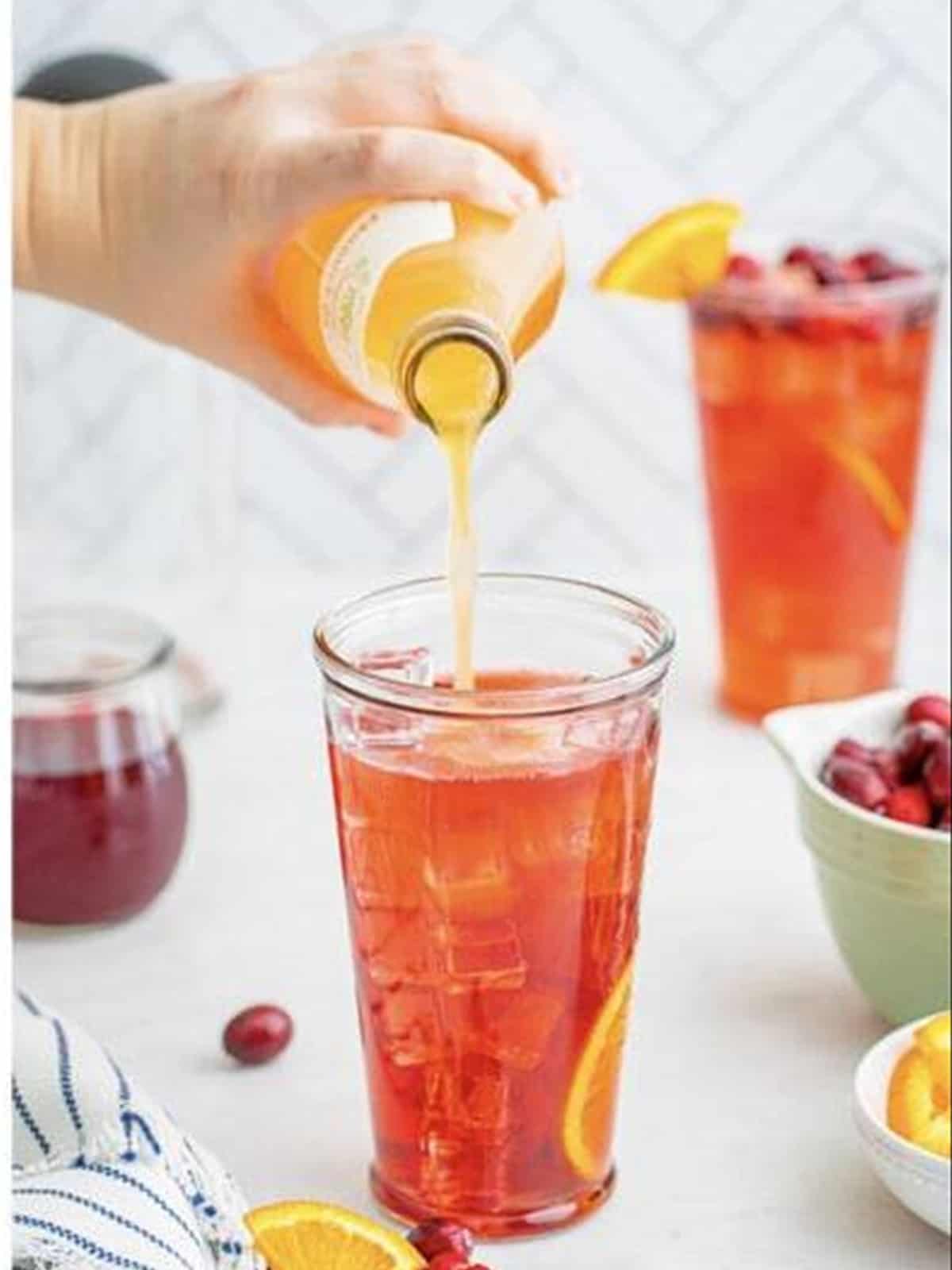 Orange soda poured over the cranberry rum punch and garnished with cranberries and orange.