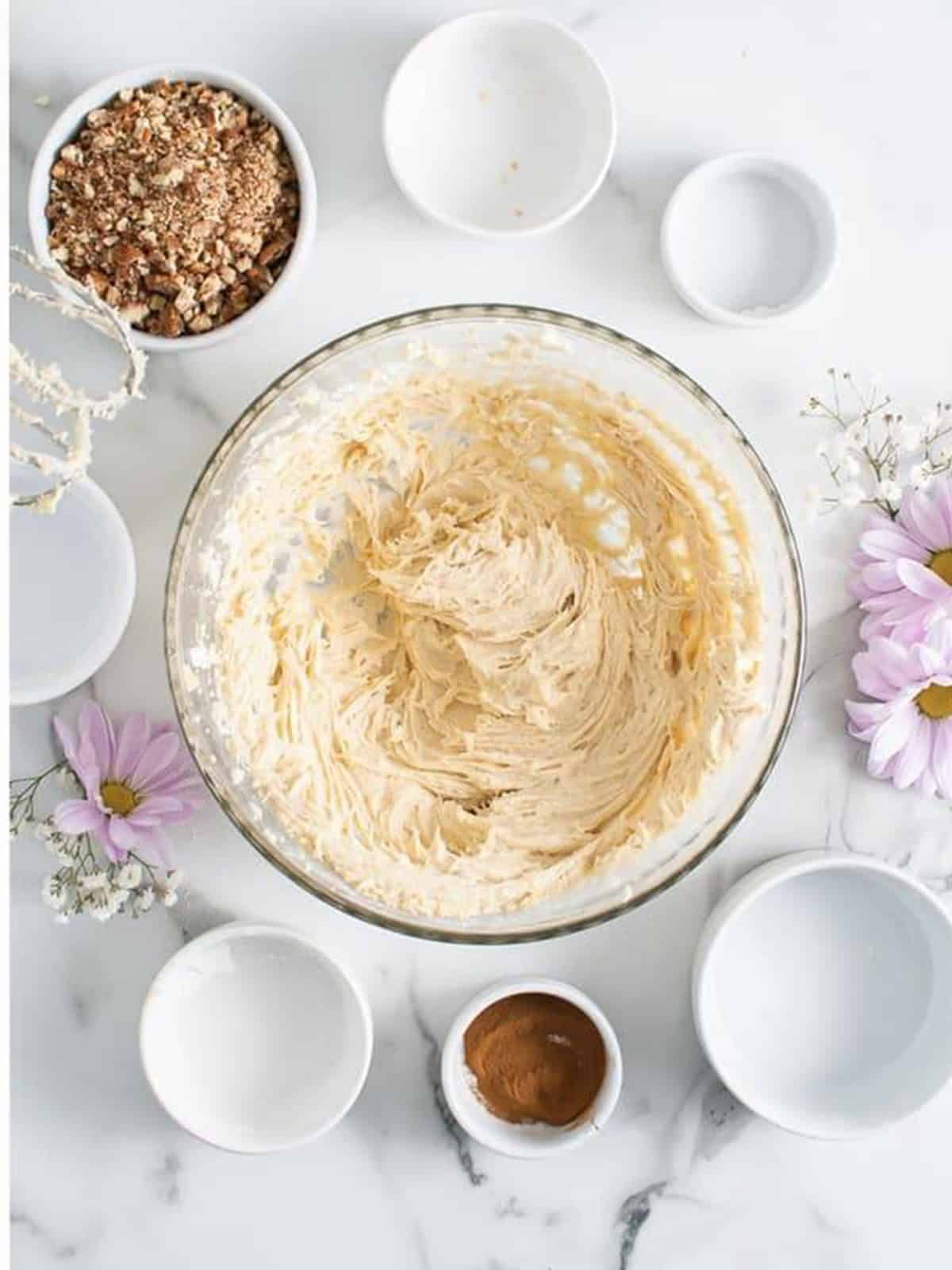 Cream cheese ball mixture beaten smooth and creamy in a glass bowl.