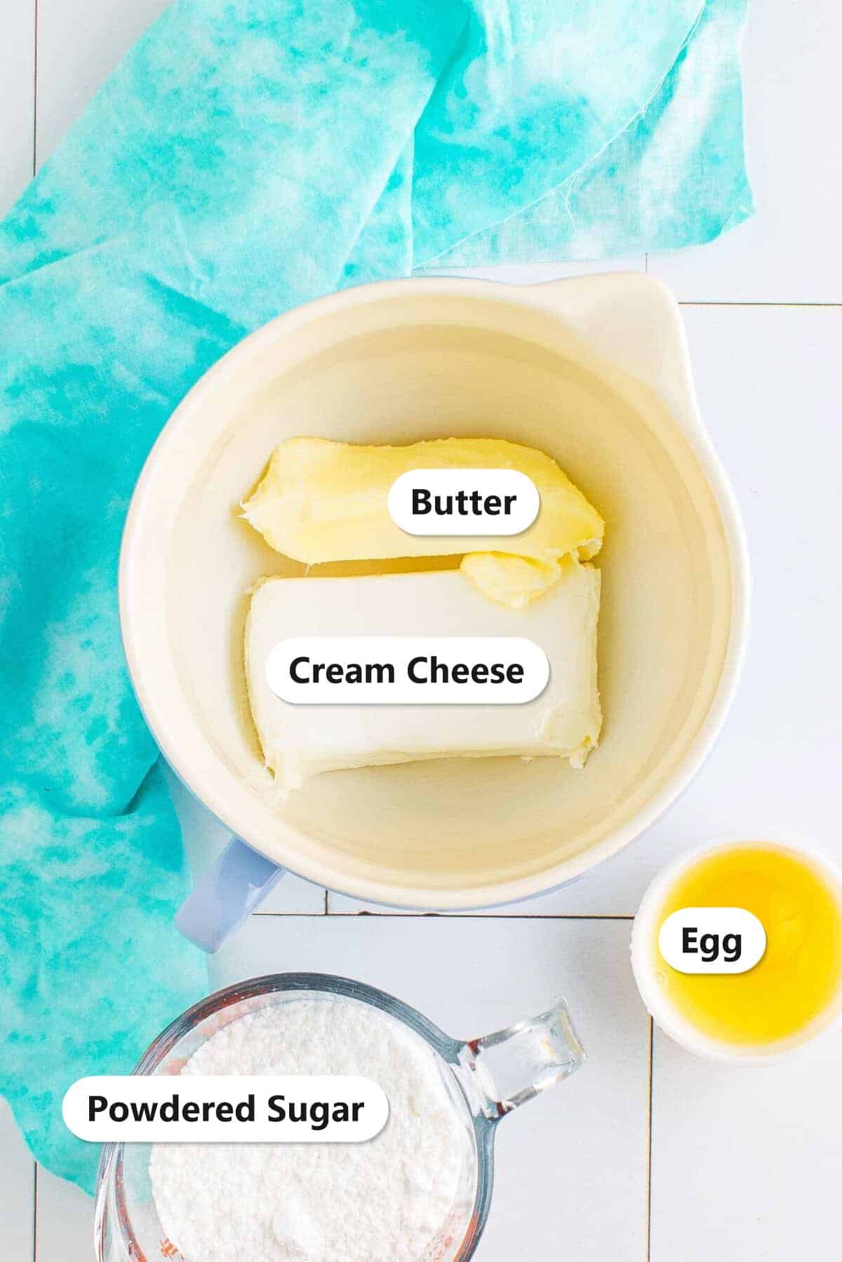 Labeled ingredients for cream cheese cookies including cream cheese, butter, powdered sugar, and egg.