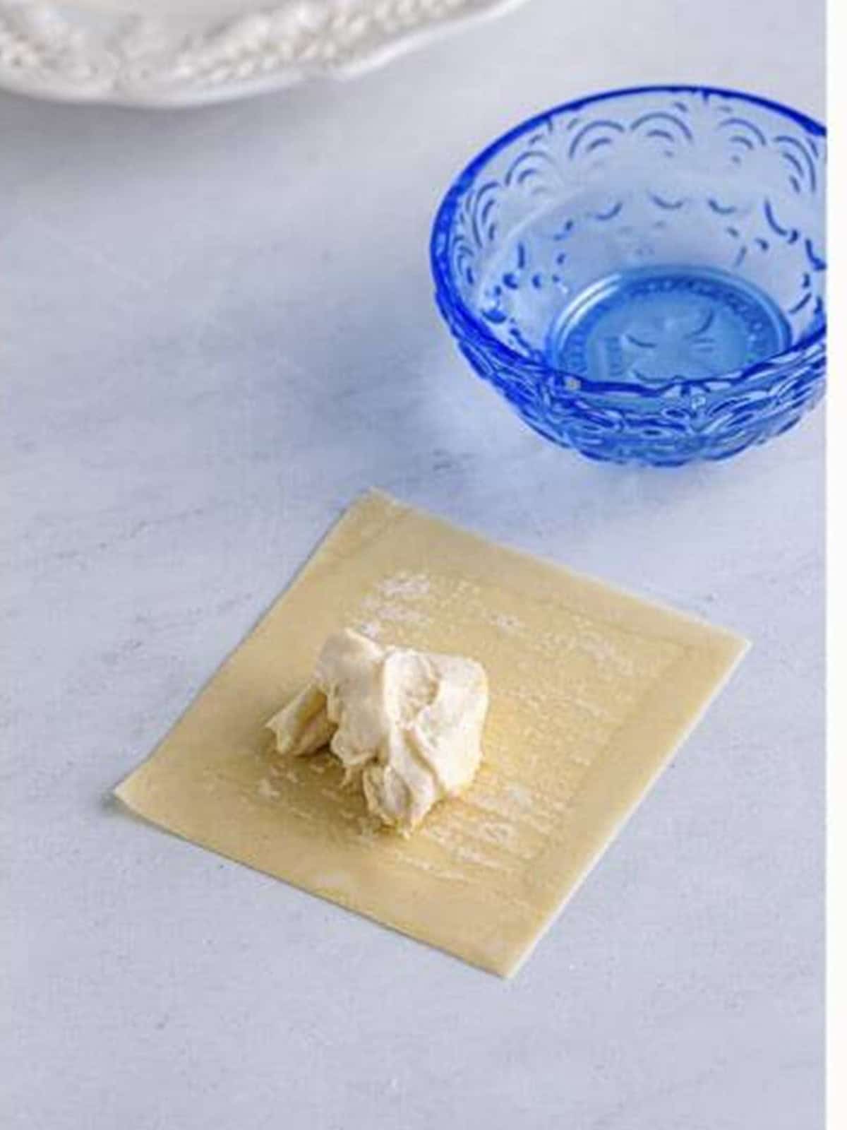 Cream cheese filling spooned into the center of a wonton wrapper.