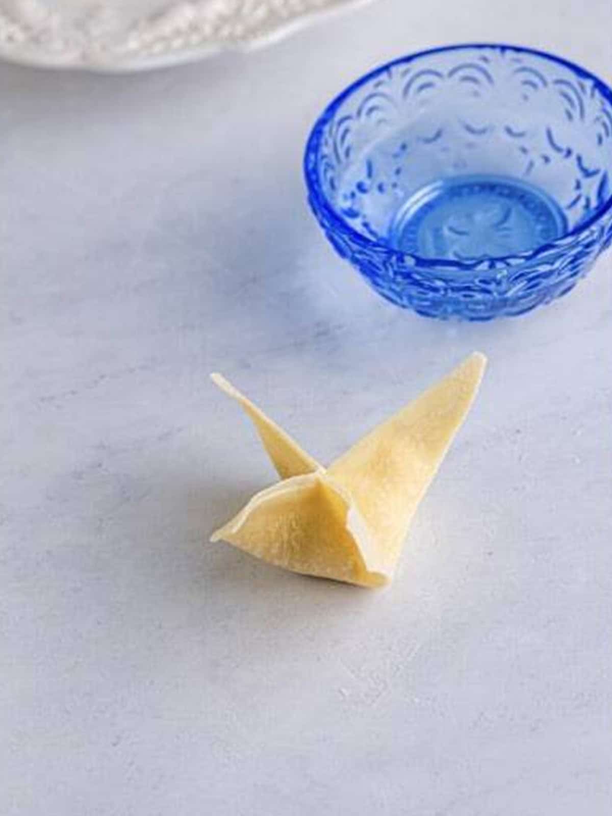 A wonton wrapper folded into four points and sealed around the filling.