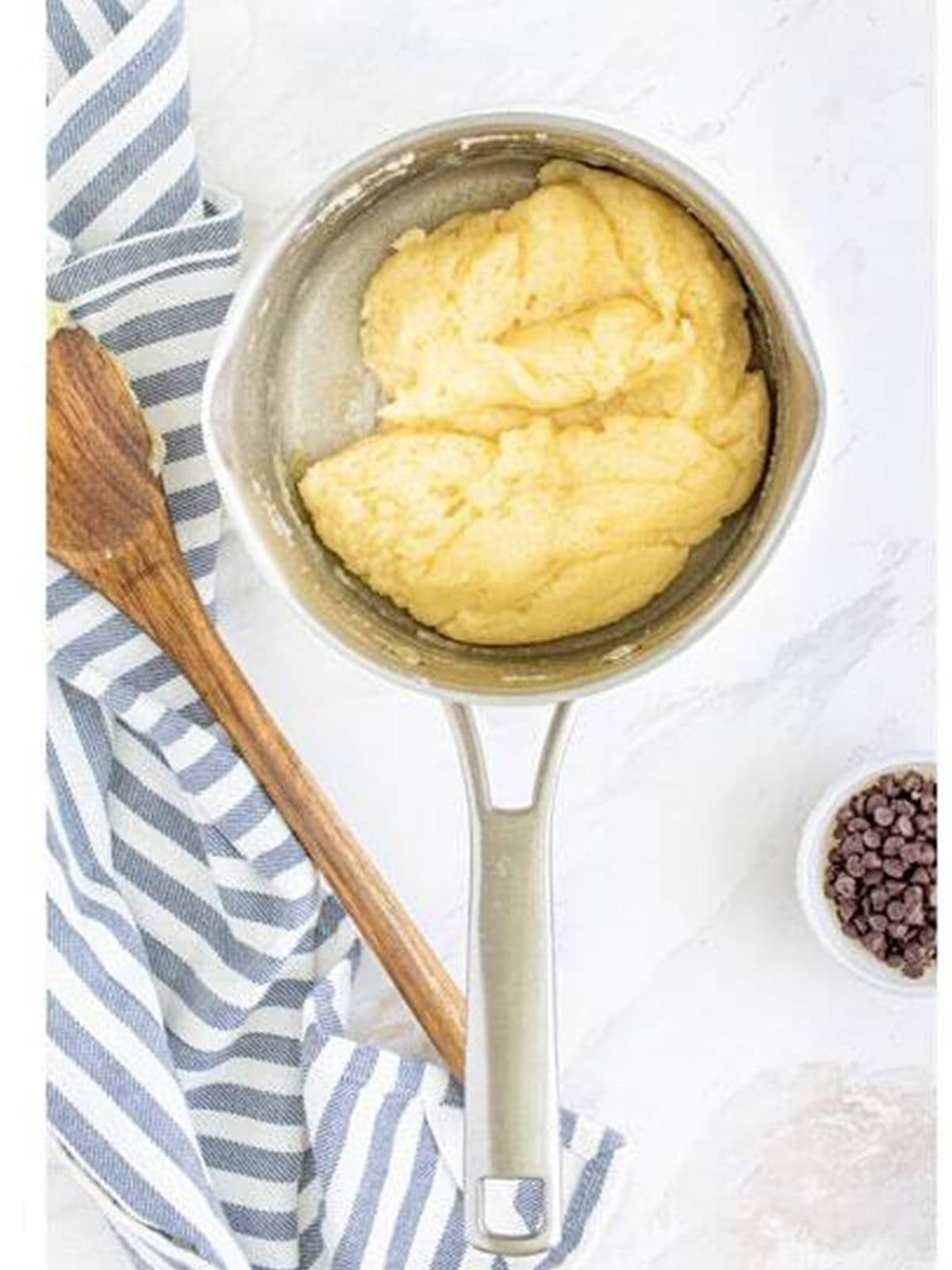 Choux pastry dough formed into a ball in a saucepan for the cream puff cake crust.