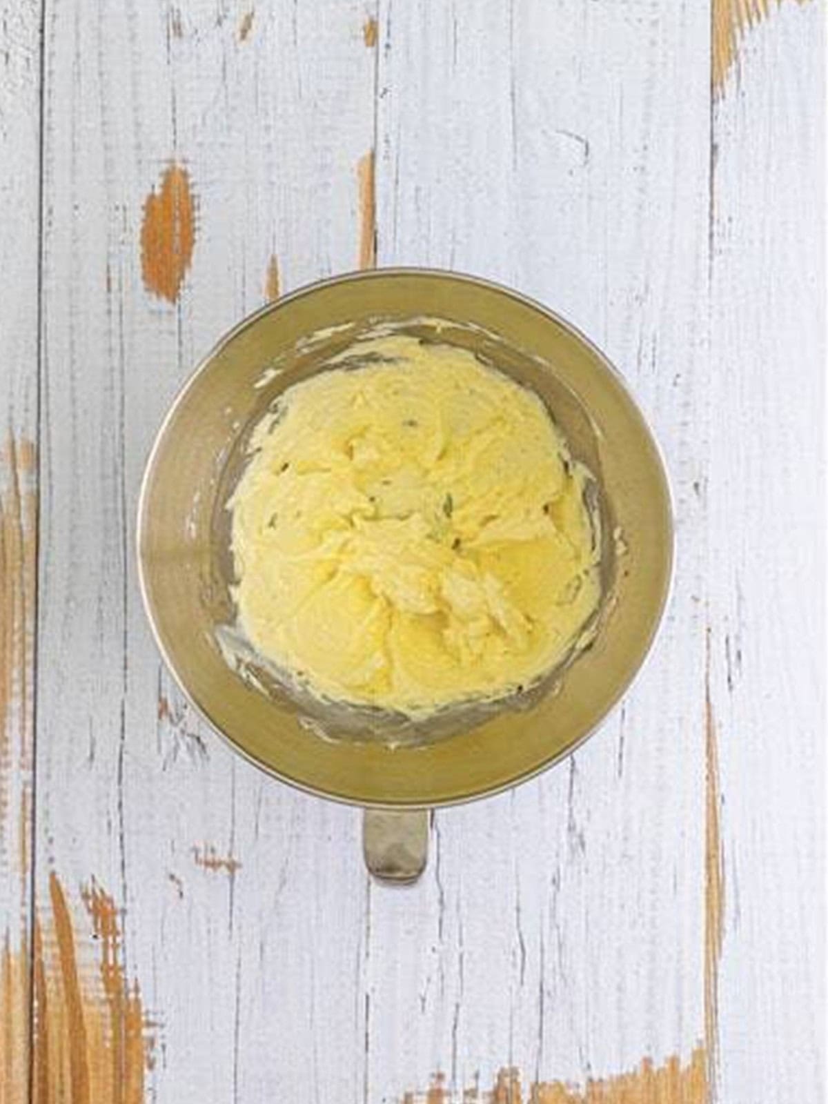 Butter and cream cheese creamed together in a mixing bowl for orange creamsicle cookies.