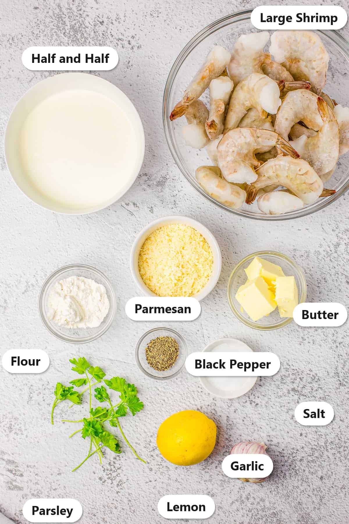 Labeled ingredients for creamy lemon shrimp including large shrimp, half and half, parmesan, butter, flour, garlic, lemon, parsley, salt, and black pepper.
