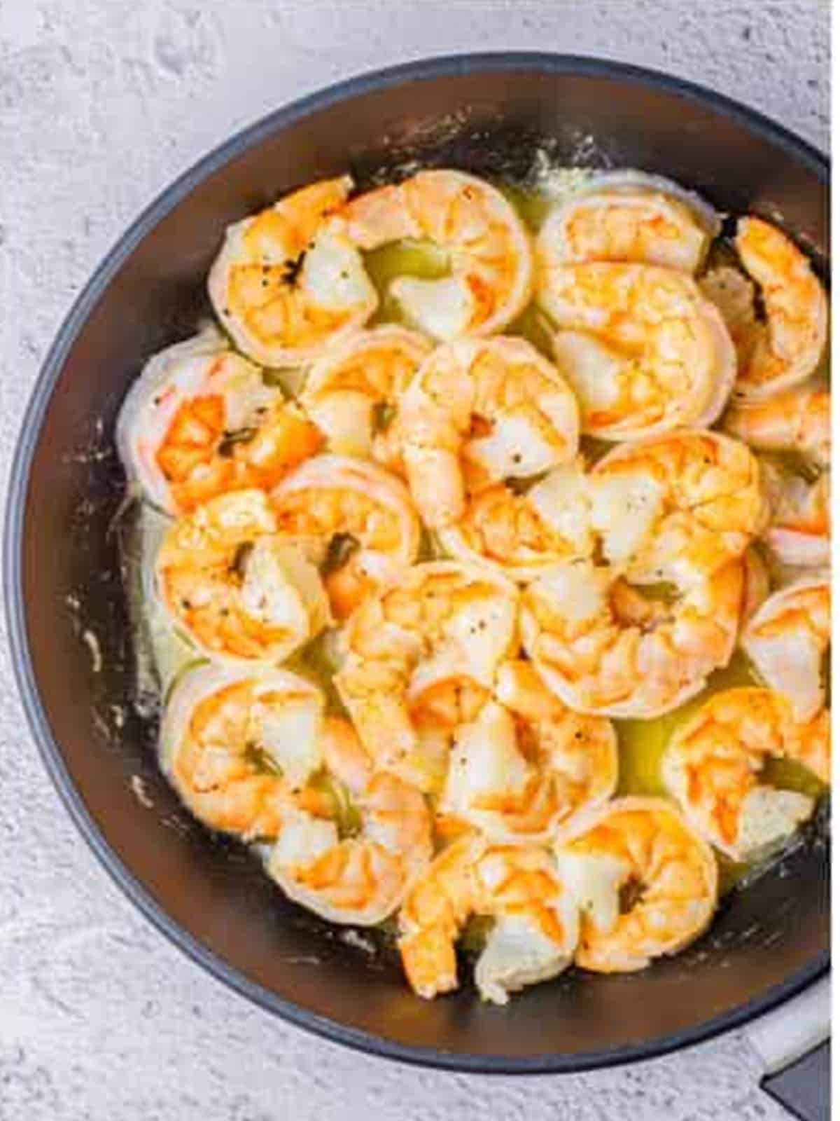 Shrimp sauteing in butter until pink for creamy lemon shrimp.