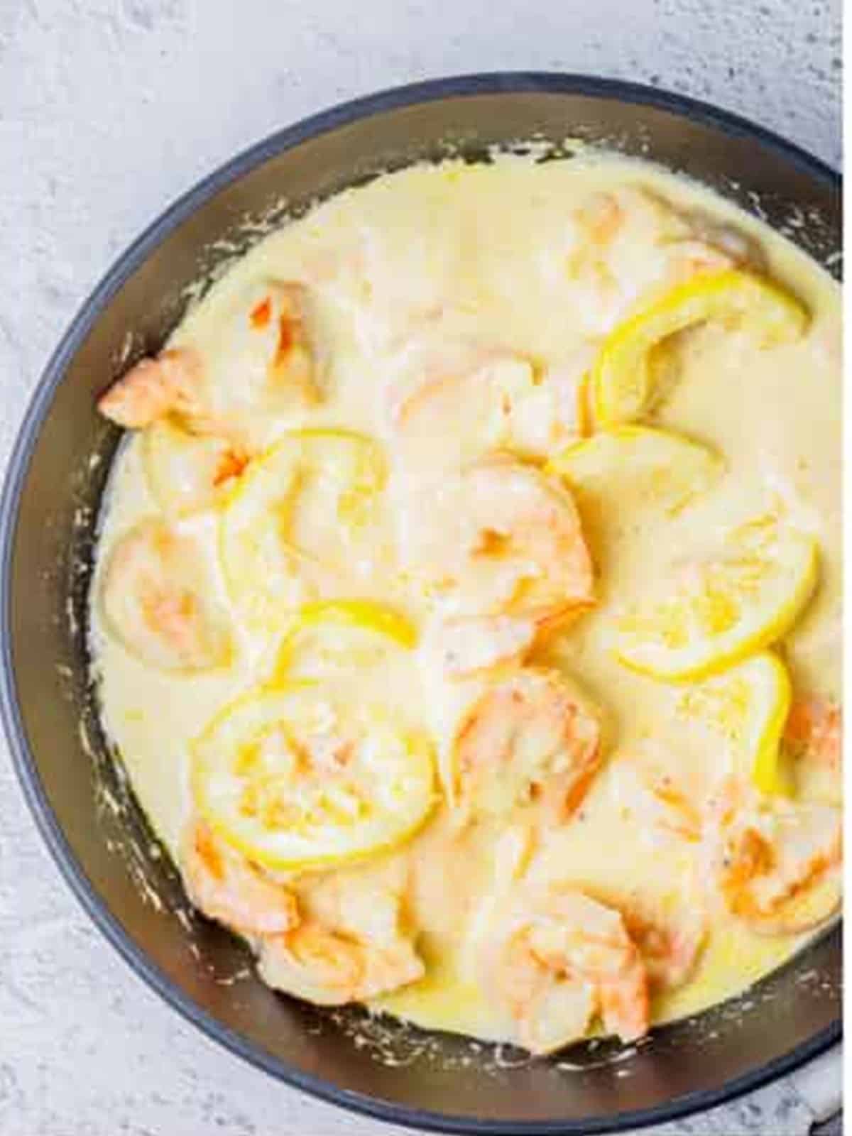 Finished creamy lemon shrimp in the skillet with lemon zest and parsley.