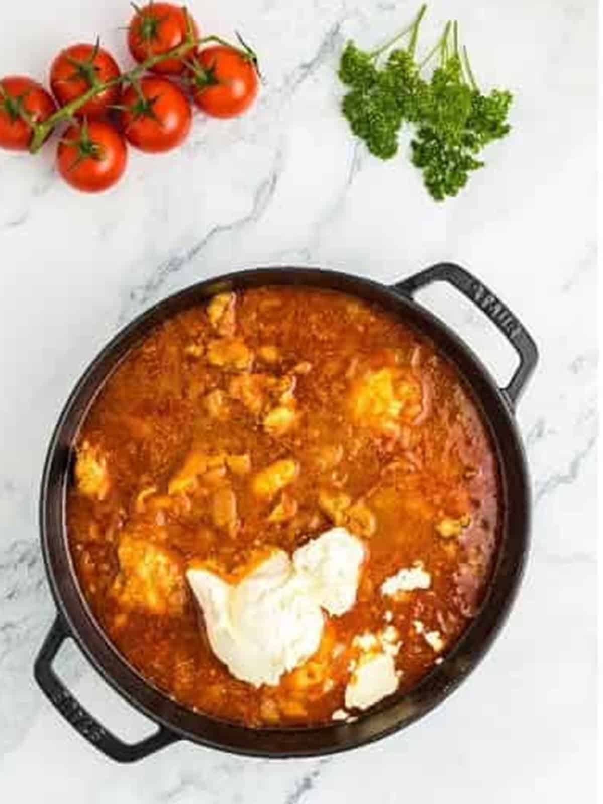 Sour cream added to the simmering paprika chicken sauce.