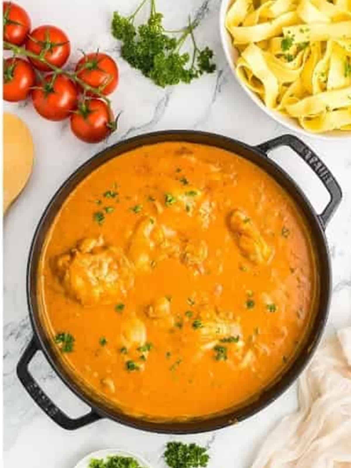 Finished creamy paprika chicken thighs garnished with fresh chopped parsley.