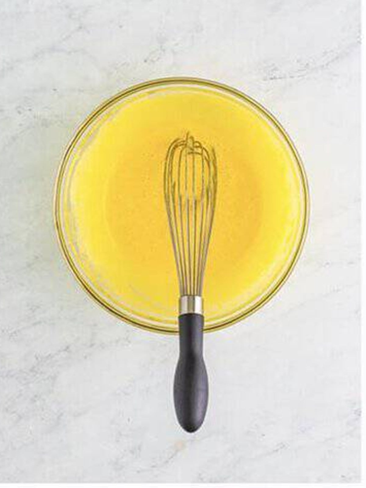 Egg yolks and sugar whisked until pale yellow in a glass bowl.