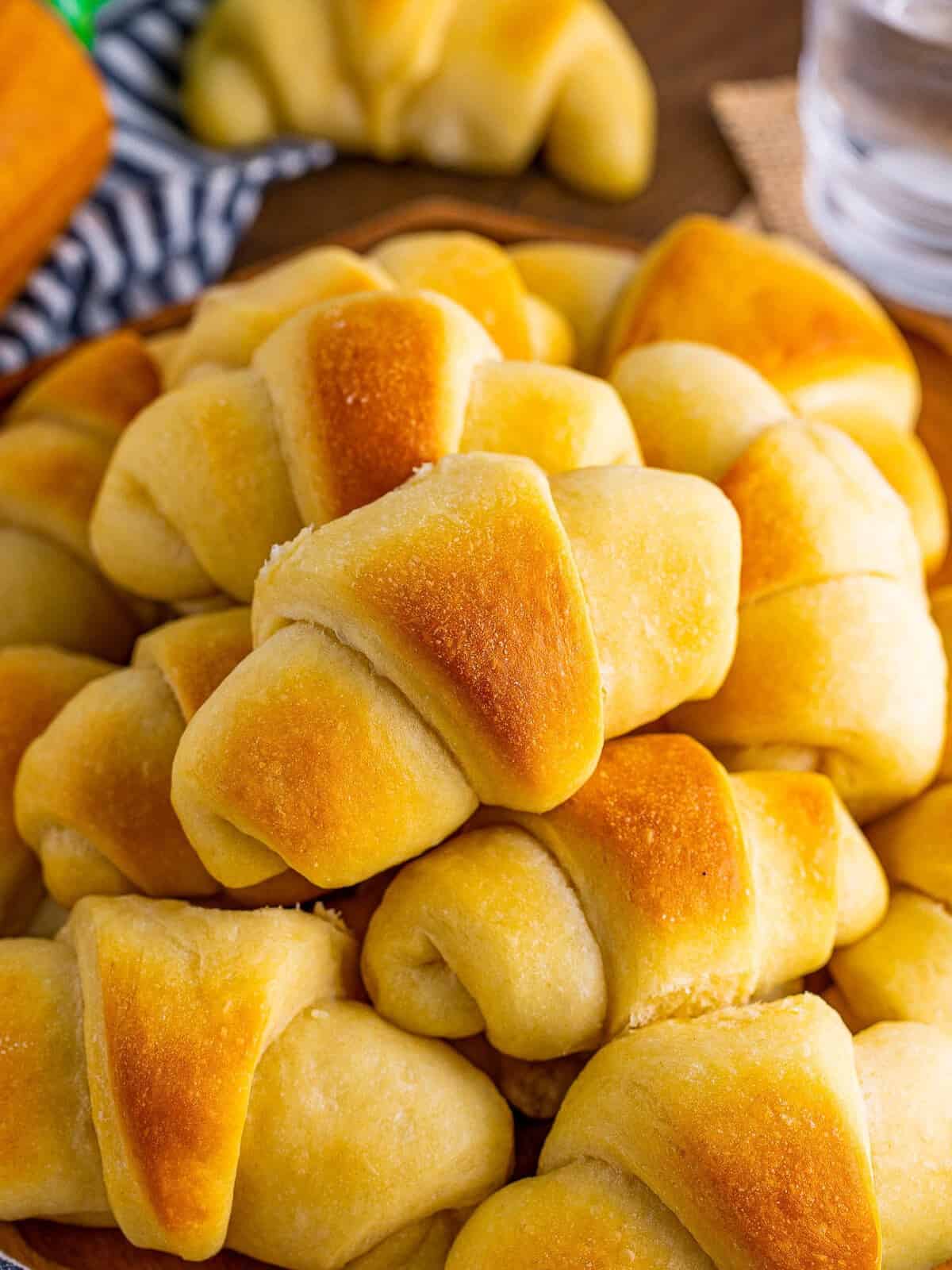 Golden baked homemade crescent rolls fresh out of the oven brushed with butter.