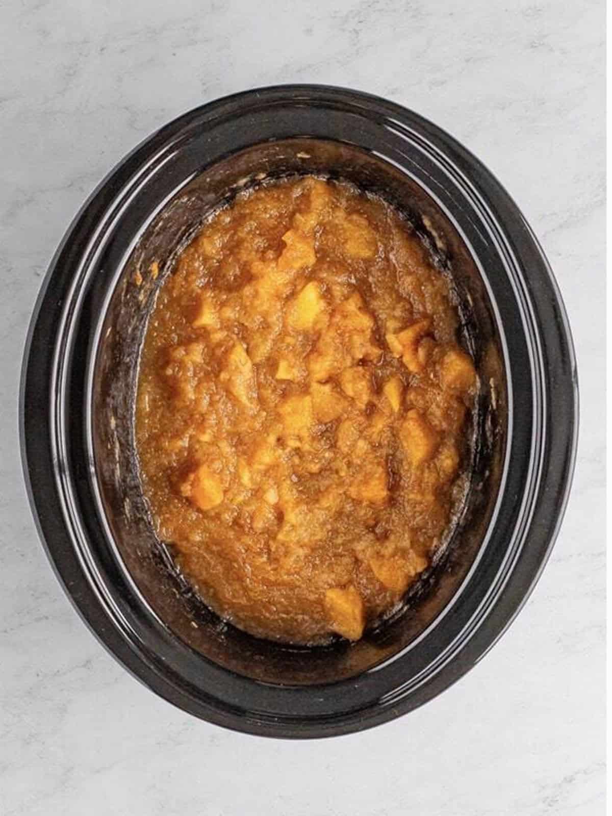 Apples cooked down until very soft in the slow cooker for homemade applesauce.