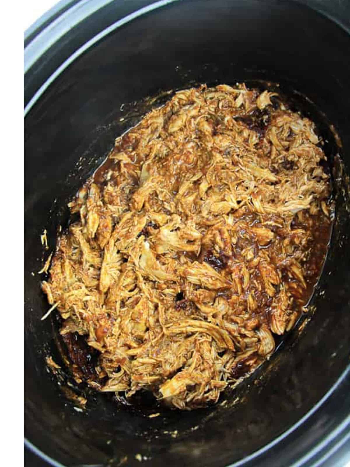 Shredded chipotle chicken in a crockpot for tacos.