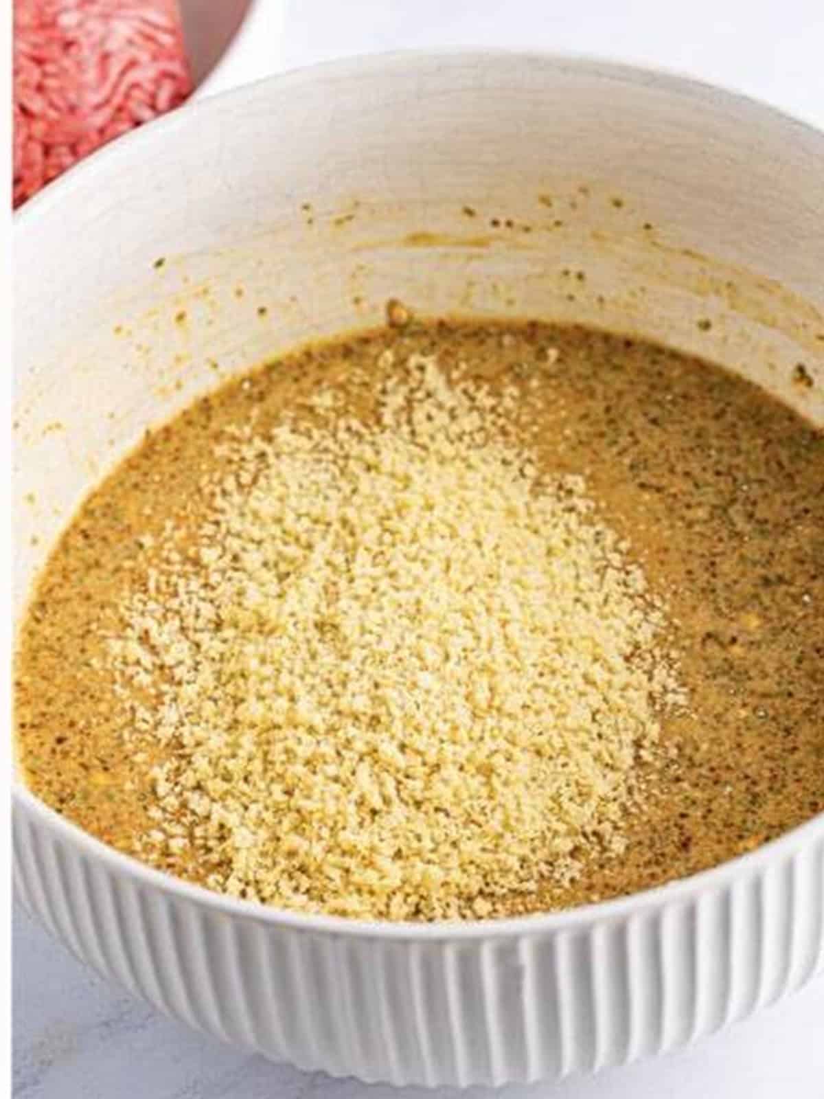 Panko breadcrumbs added to the whisked wet base for crockpot meatloaf.