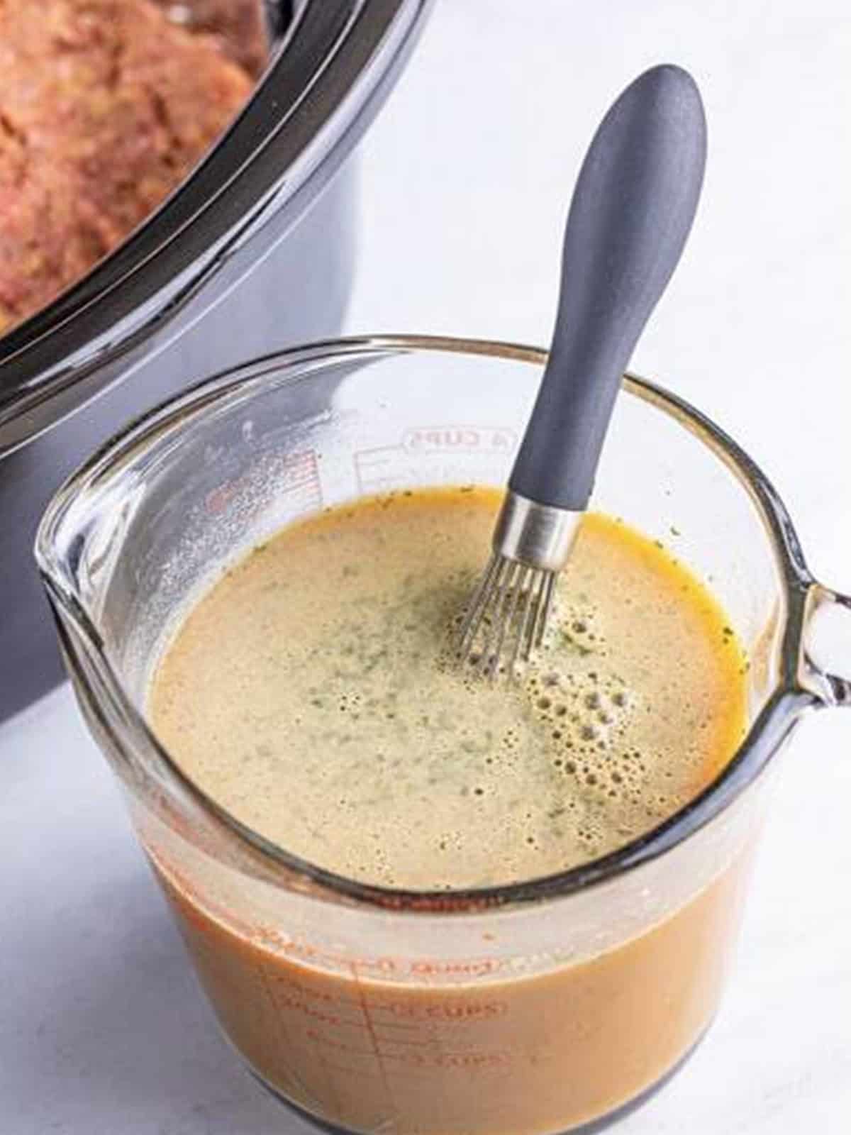 Mississippi gravy whisked together in a measuring cup with au jus and ranch packets.