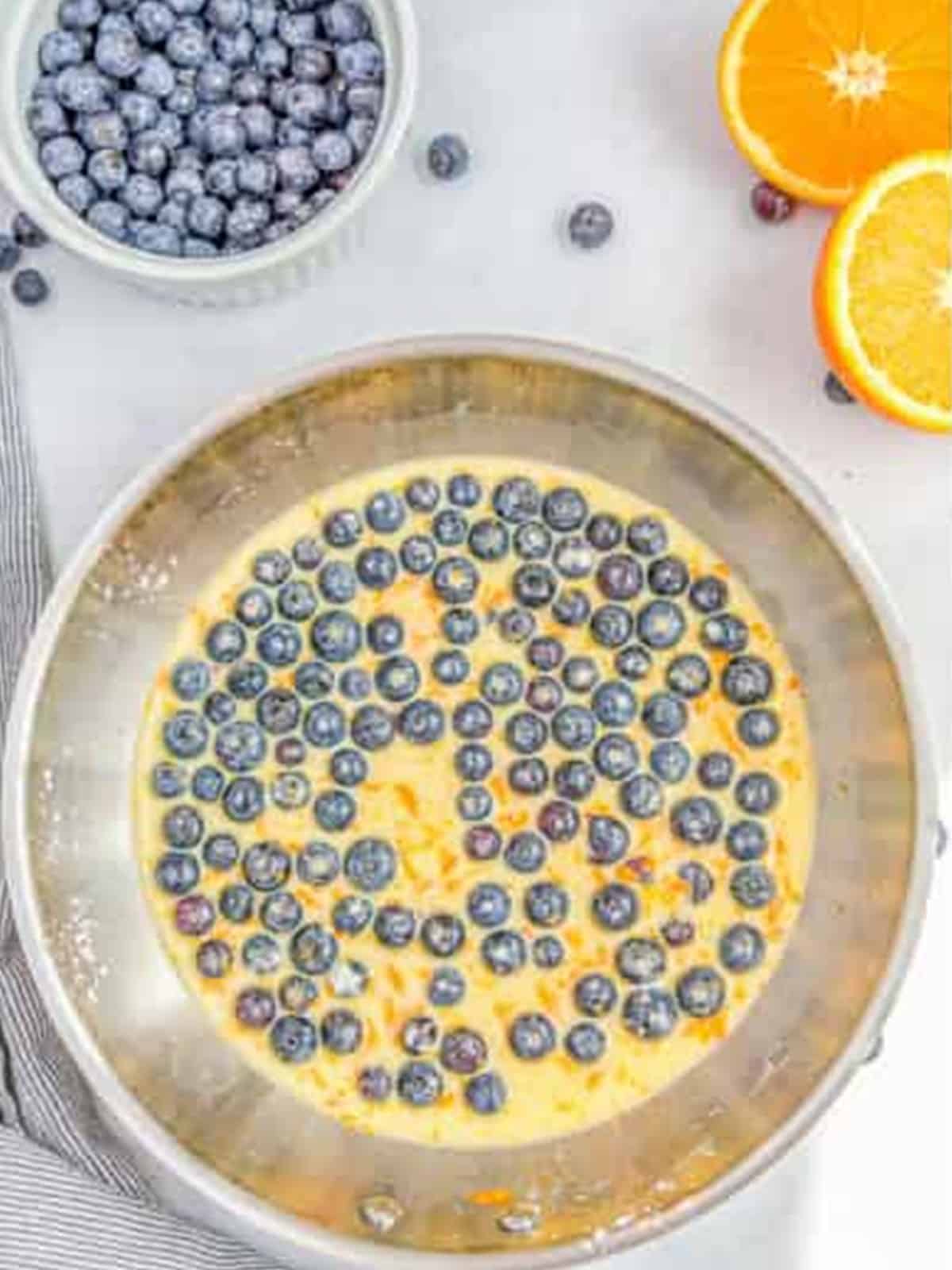 Blueberries, orange juice, sugar, and zest simmering in a skillet for the sauce.