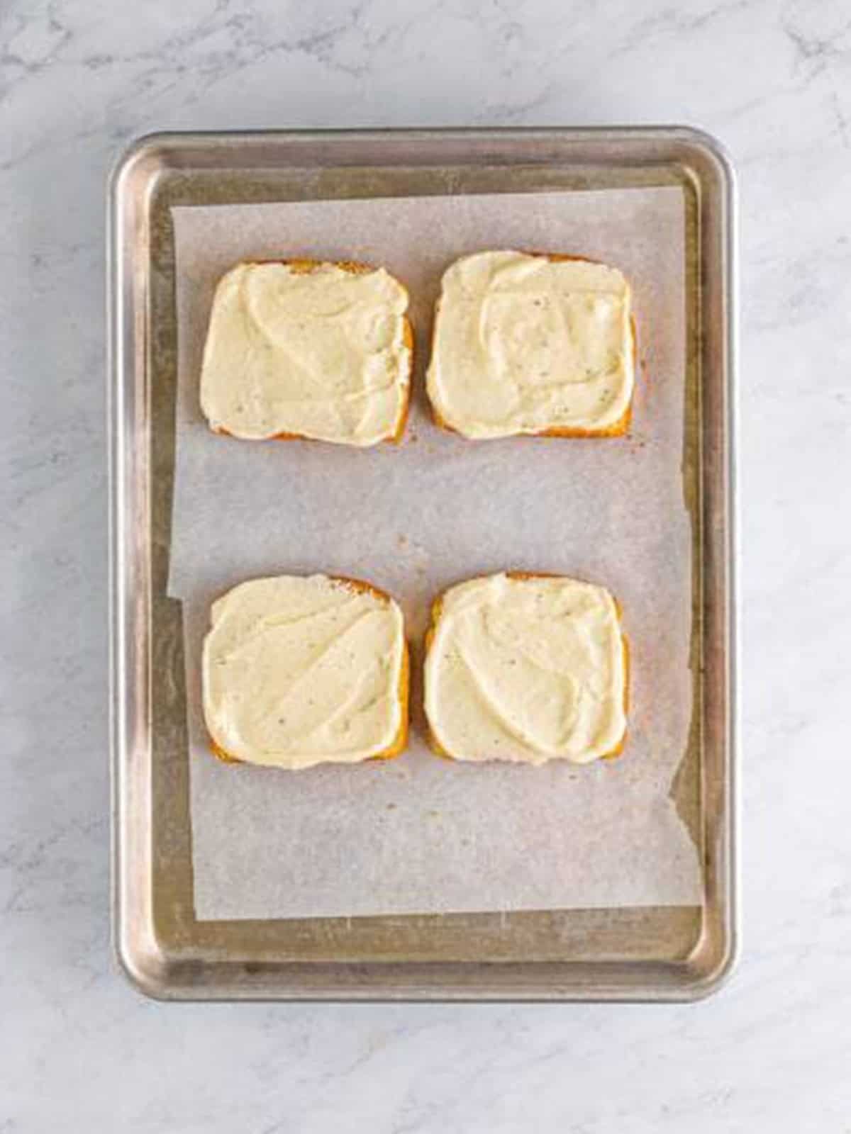 Bechamel sauce and ham layered on toasted bread for croque monsieur.