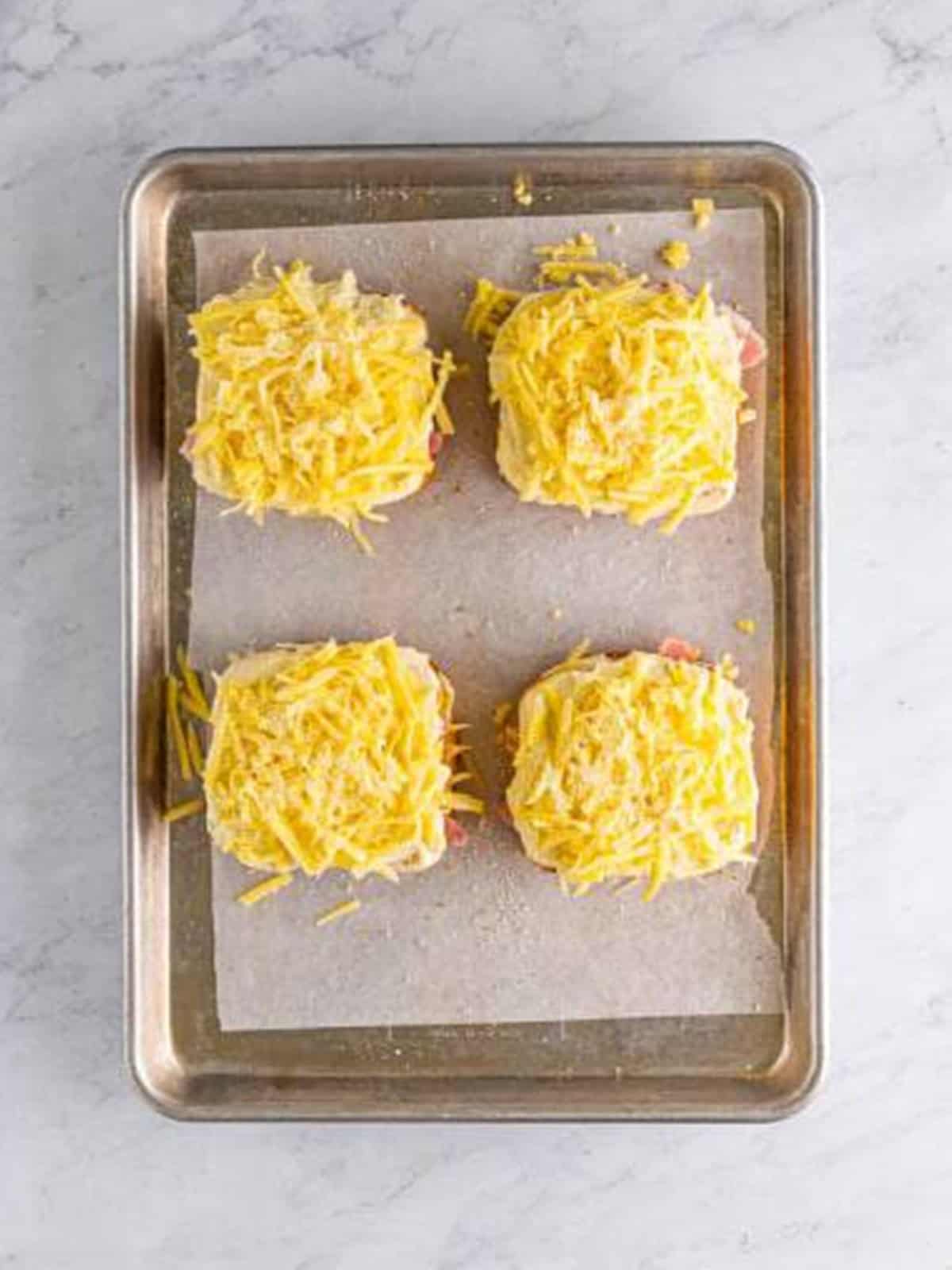 Top slices of bread smeared with bechamel and topped with more cheese.