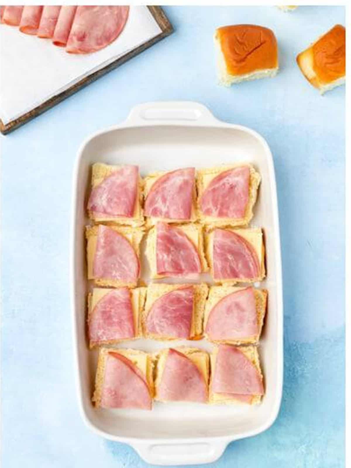 Swiss cheese and deli ham layered on the rolls for Cuban sliders.