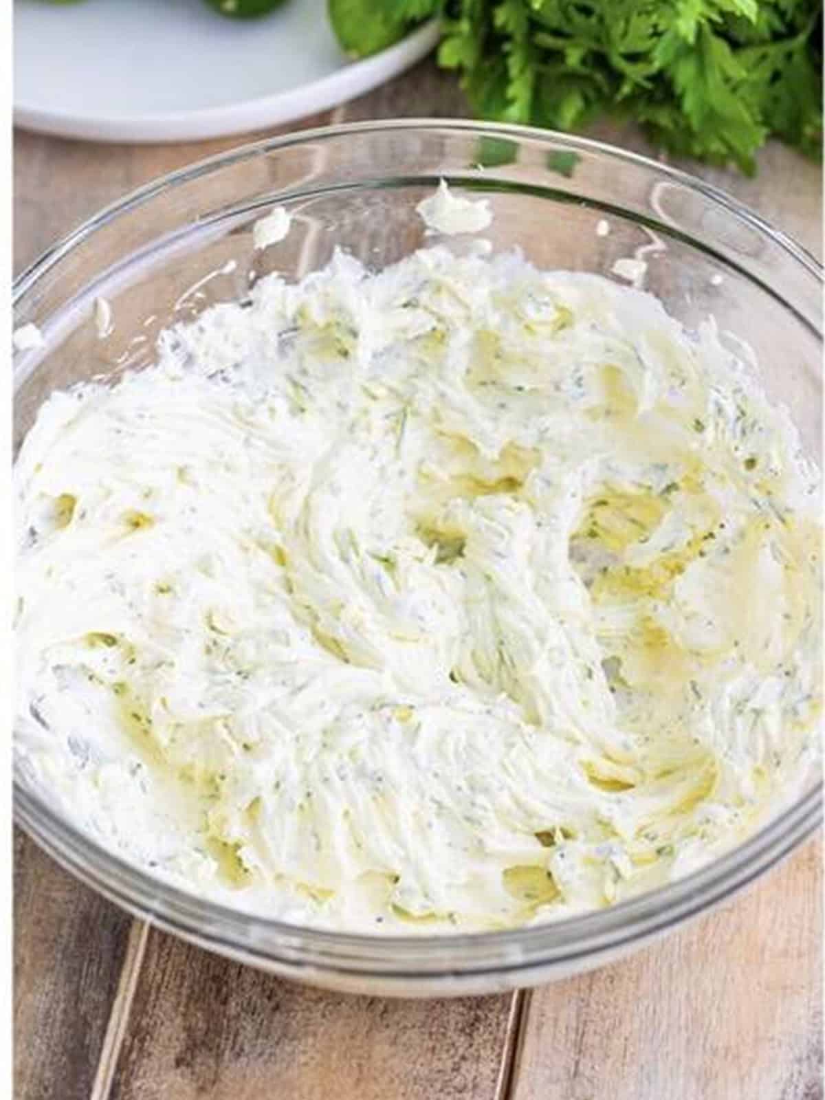 Cream cheese and herb filling whipped smooth in a glass bowl.