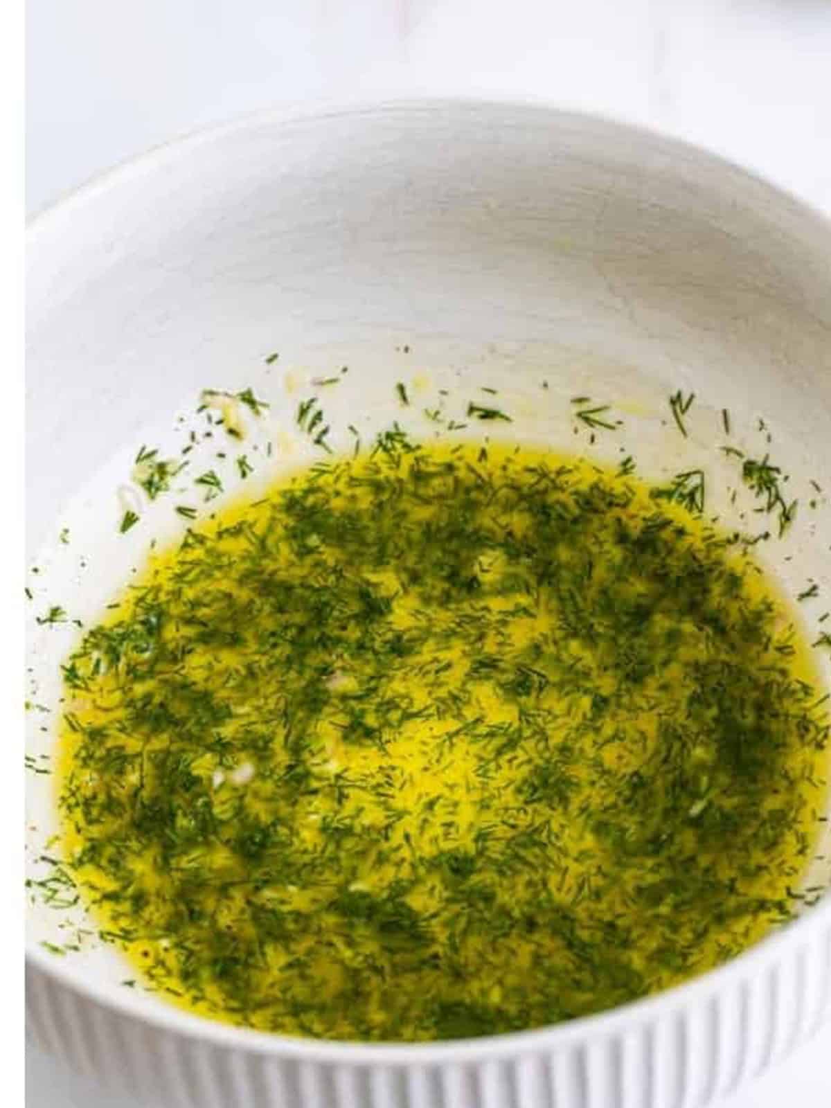 The lemon dill dressing whisked together in a bowl.