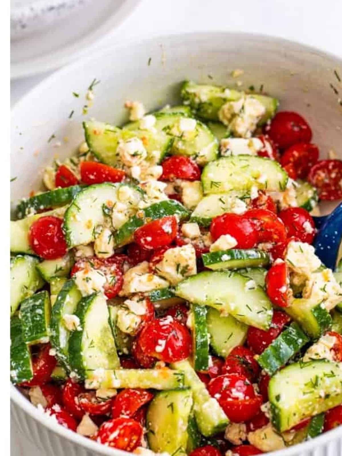 Cucumber tomato feta salad tossed together in a bowl.