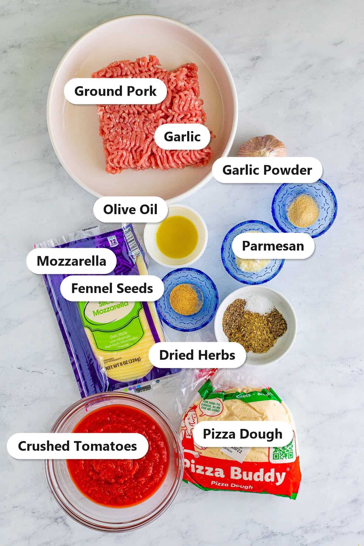 Labeled ingredients to make deep dish pizza including ground pork, mozzarella, crushed tomatoes, and pizza dough.