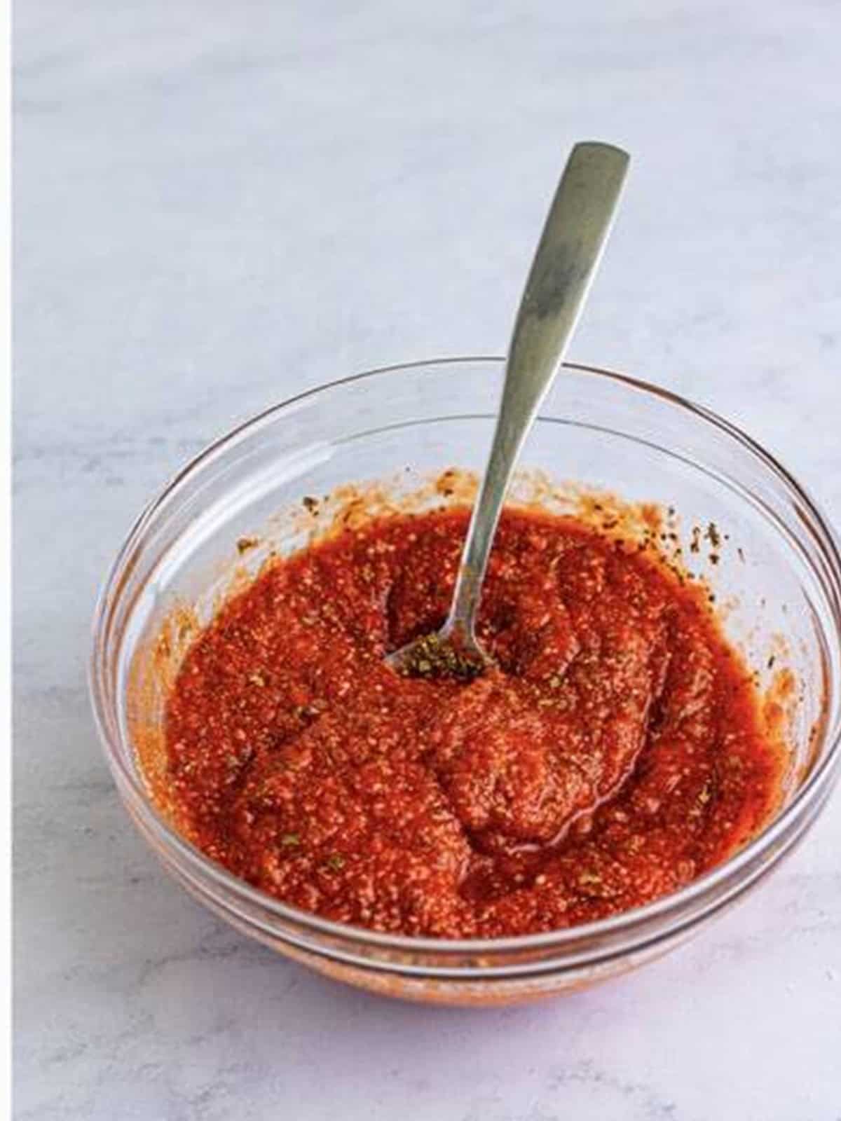 Homemade pizza sauce mixed in a glass bowl for deep dish pizza.