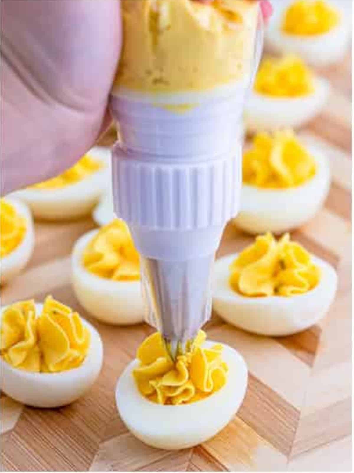 Finished deviled eggs garnished with paprika and chives.