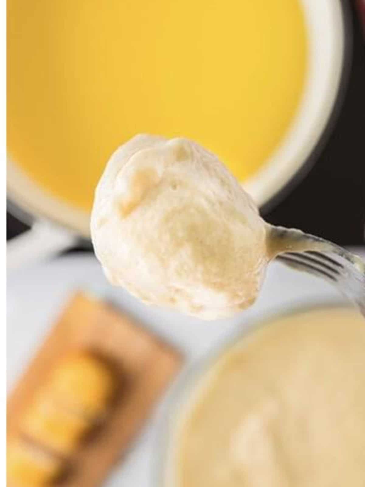 A Twinkie bite being dipped into frying batter with a spoon.