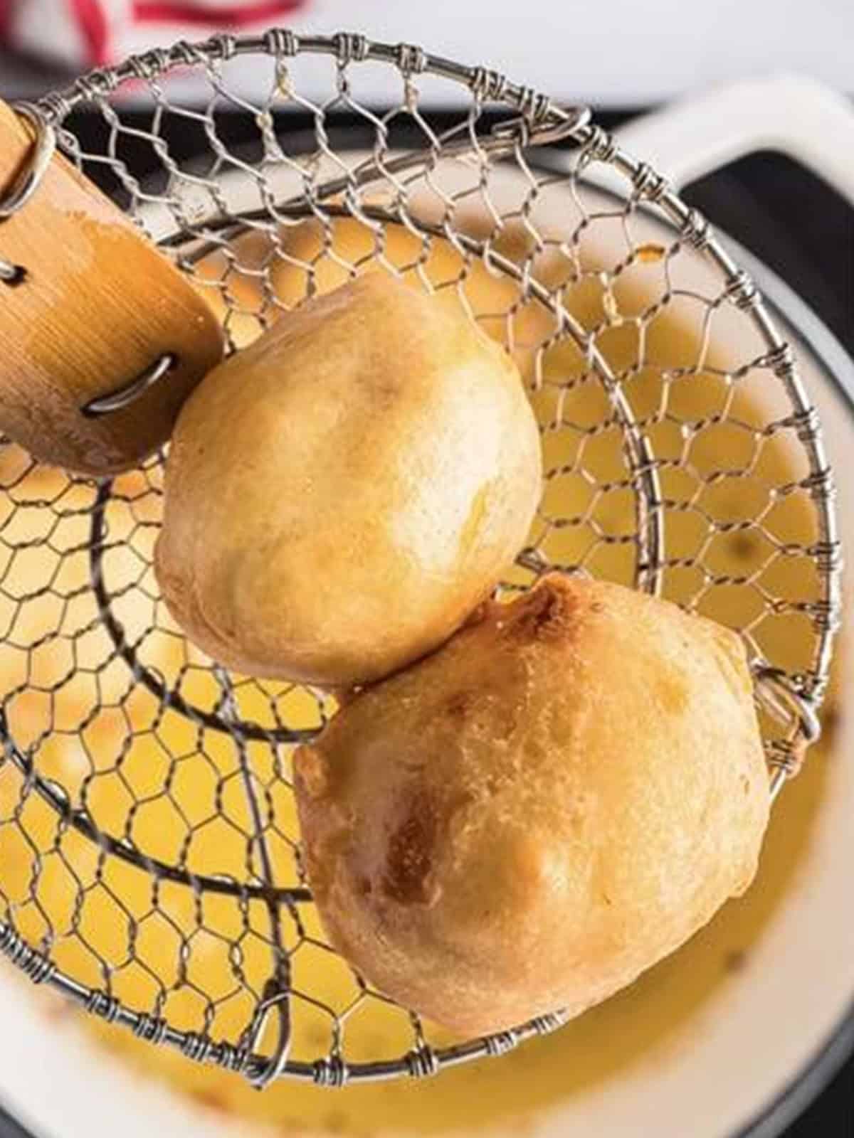Battered Twinkie bites frying to golden brown in hot oil.