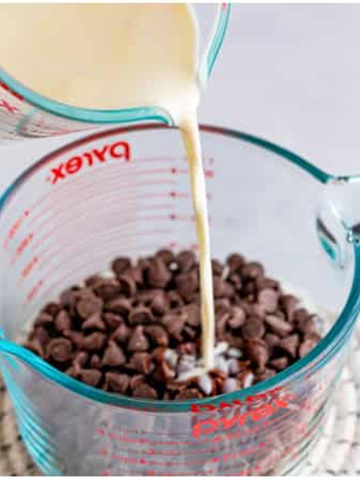 Hot cream poured over chocolate chips to make the ganache topping.