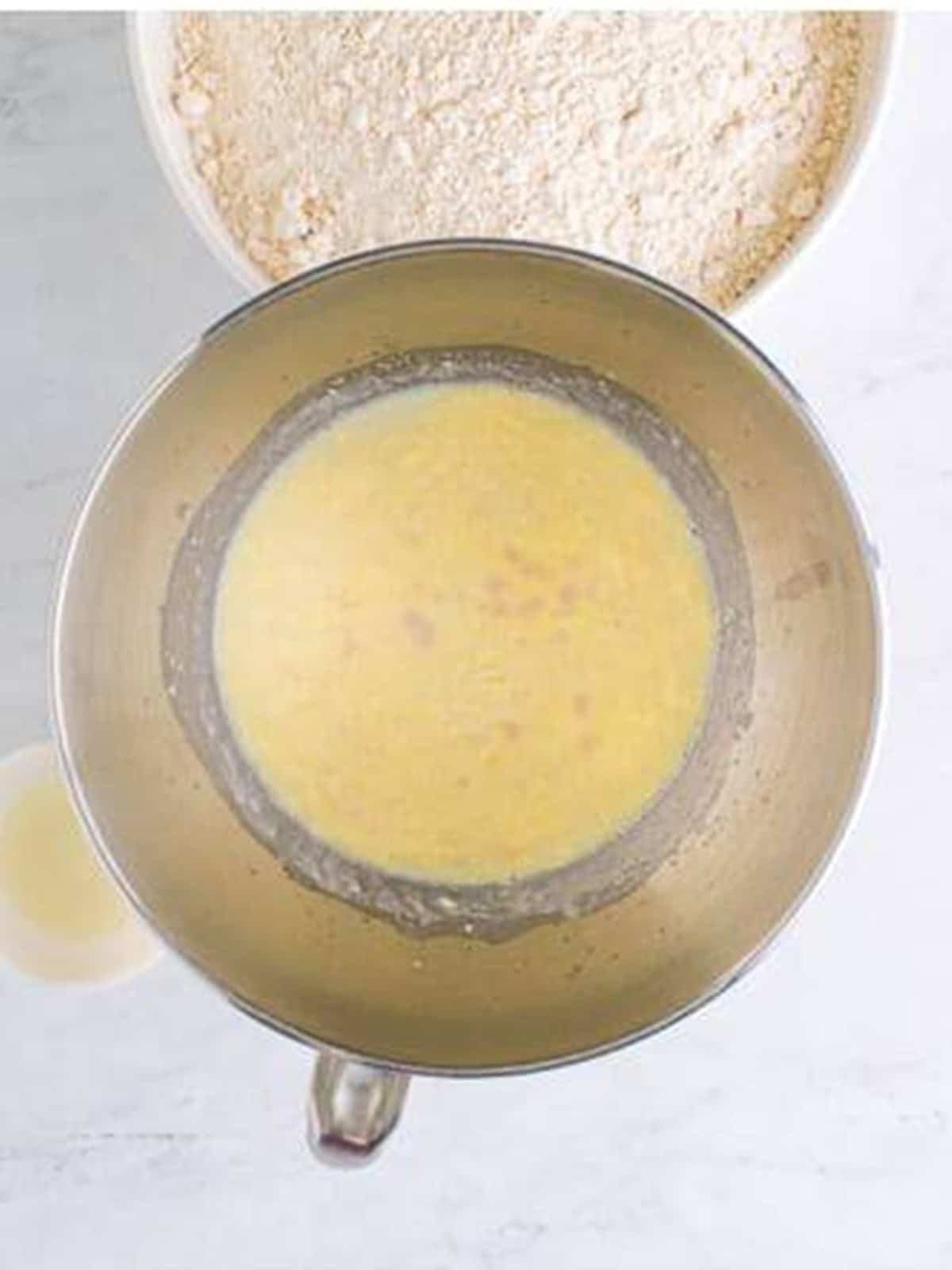 Warm milk and foamy yeast mixture added to the mixer bowl.