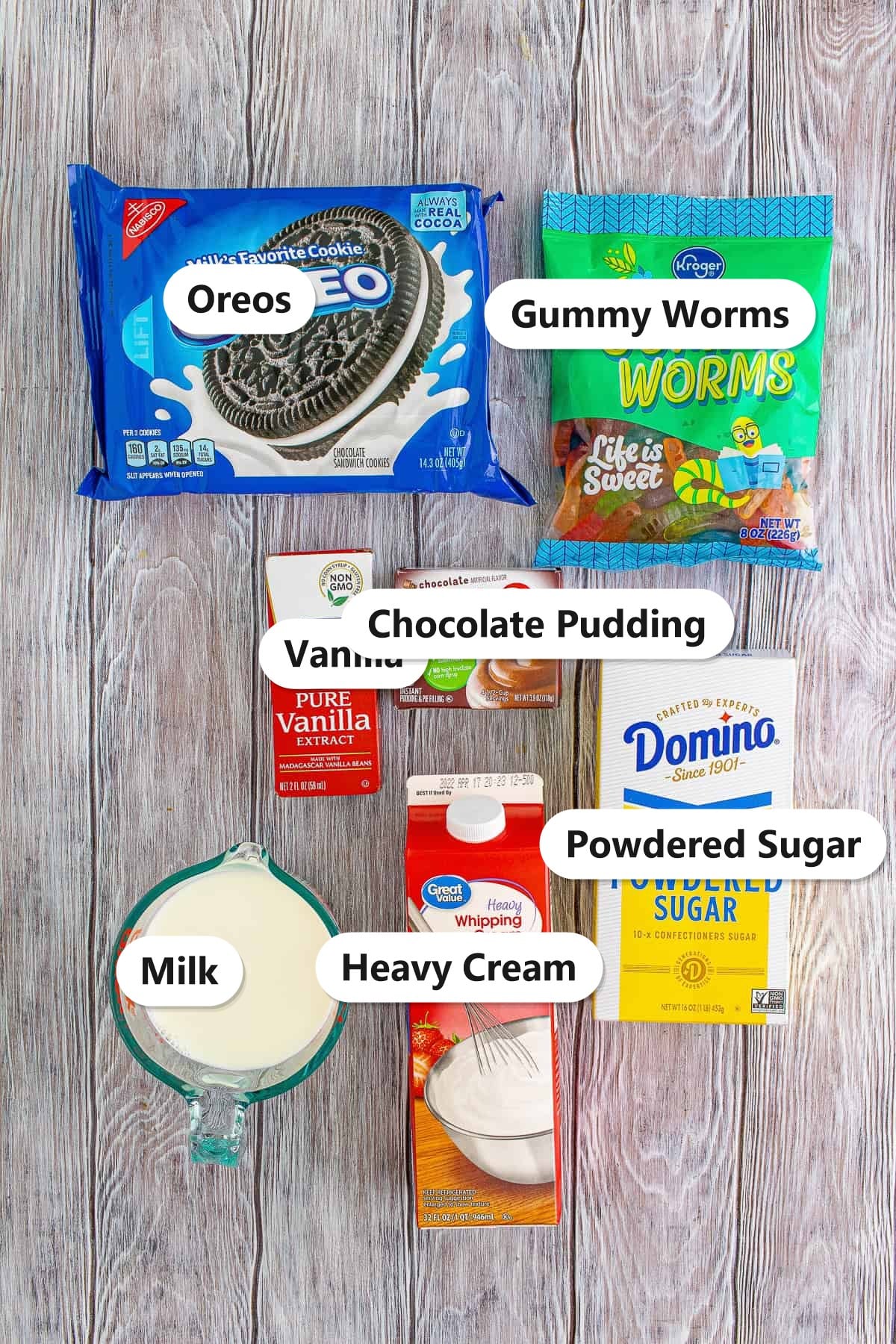 Labeled ingredients for dirt cups: Oreos, gummy worms, vanilla, instant chocolate pudding, powdered sugar, heavy cream, and milk.