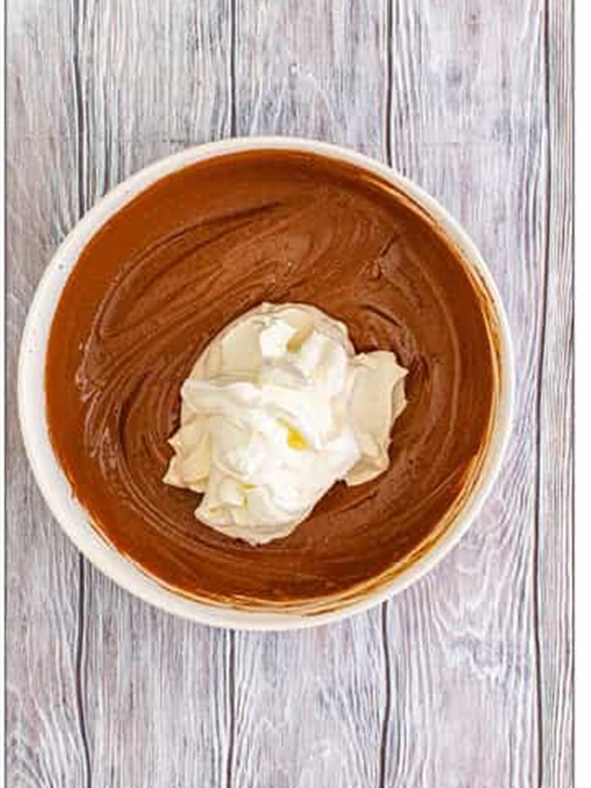 Whipped cream being folded into chocolate pudding.