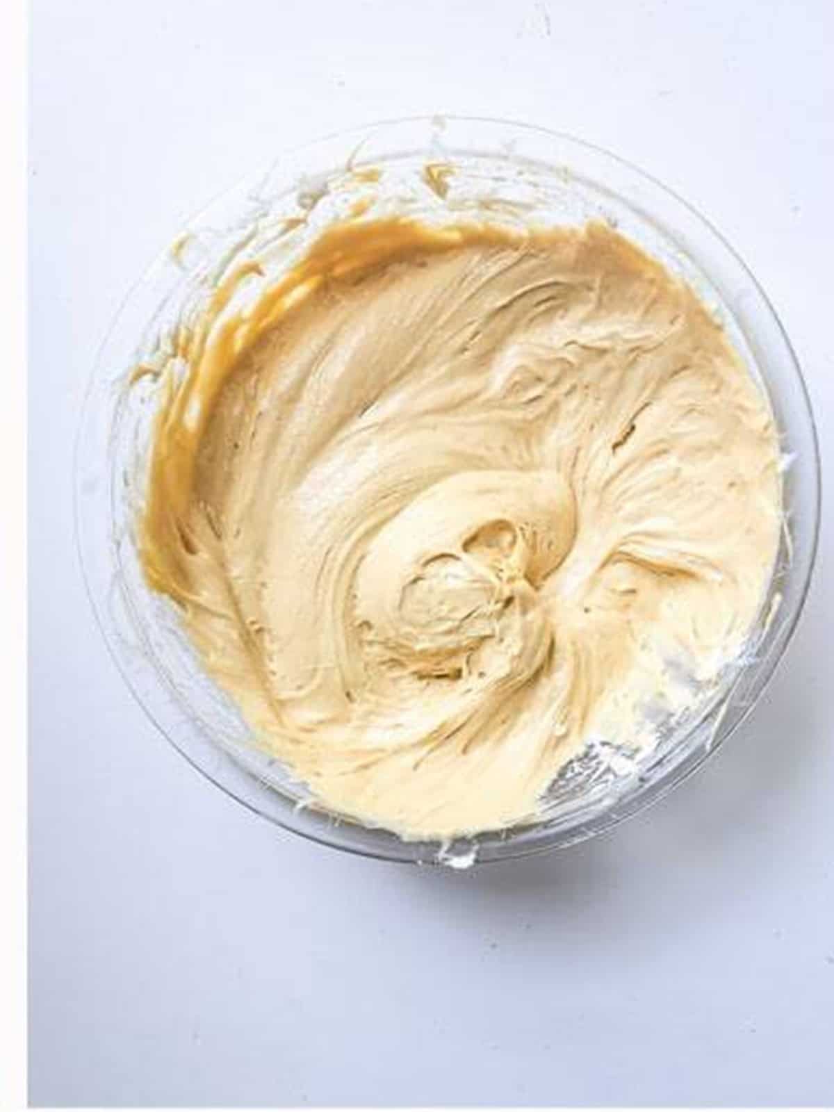 Smooth dulce de leche cheesecake filling blended in a glass bowl.