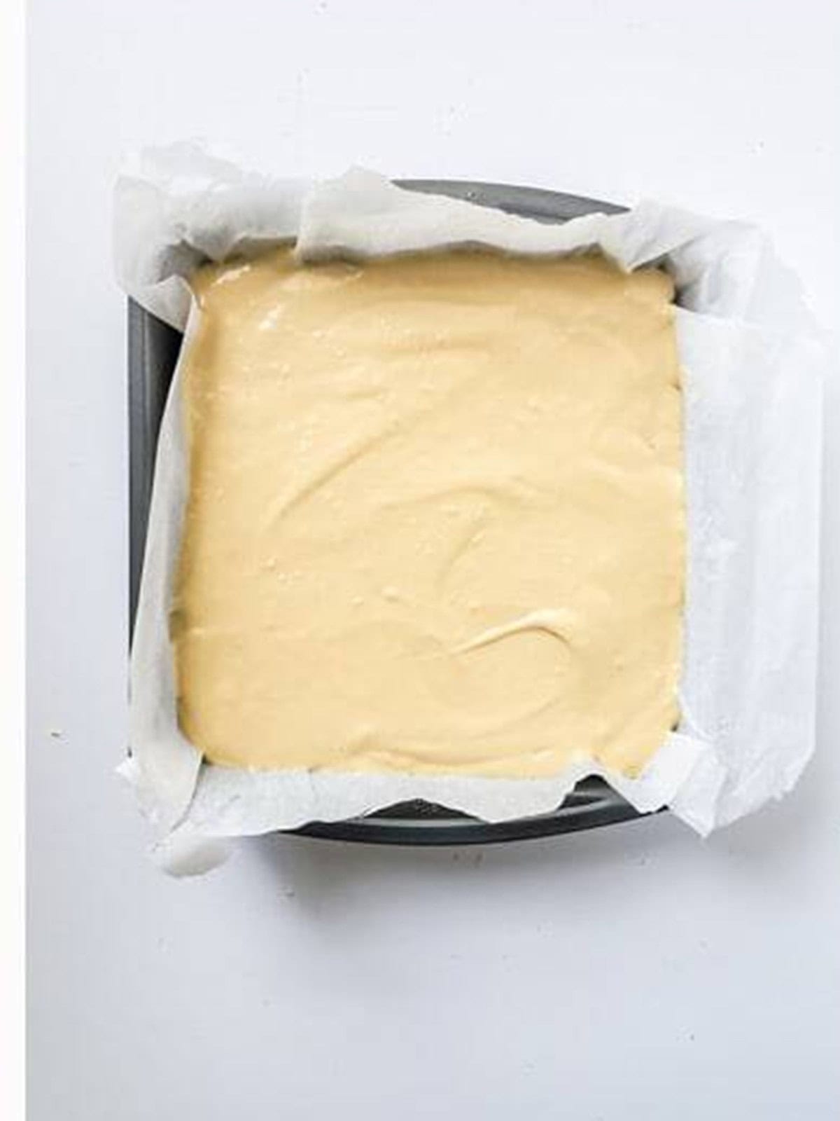 Dulce de leche cheesecake batter poured over the graham crust in the pan before baking.