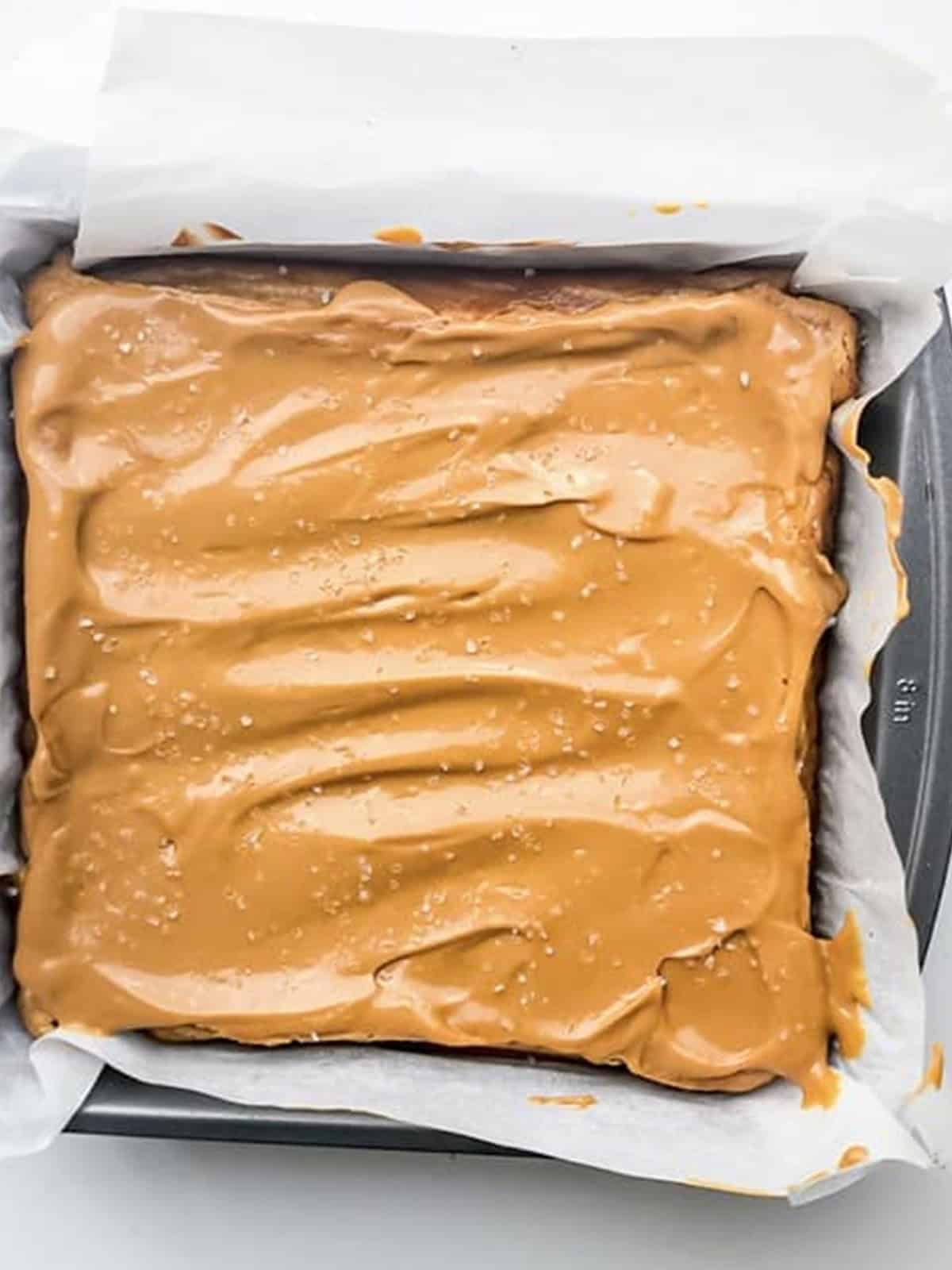 Finished dulce de leche cheesecake topped with whipped caramel and sea salt in the pan.
