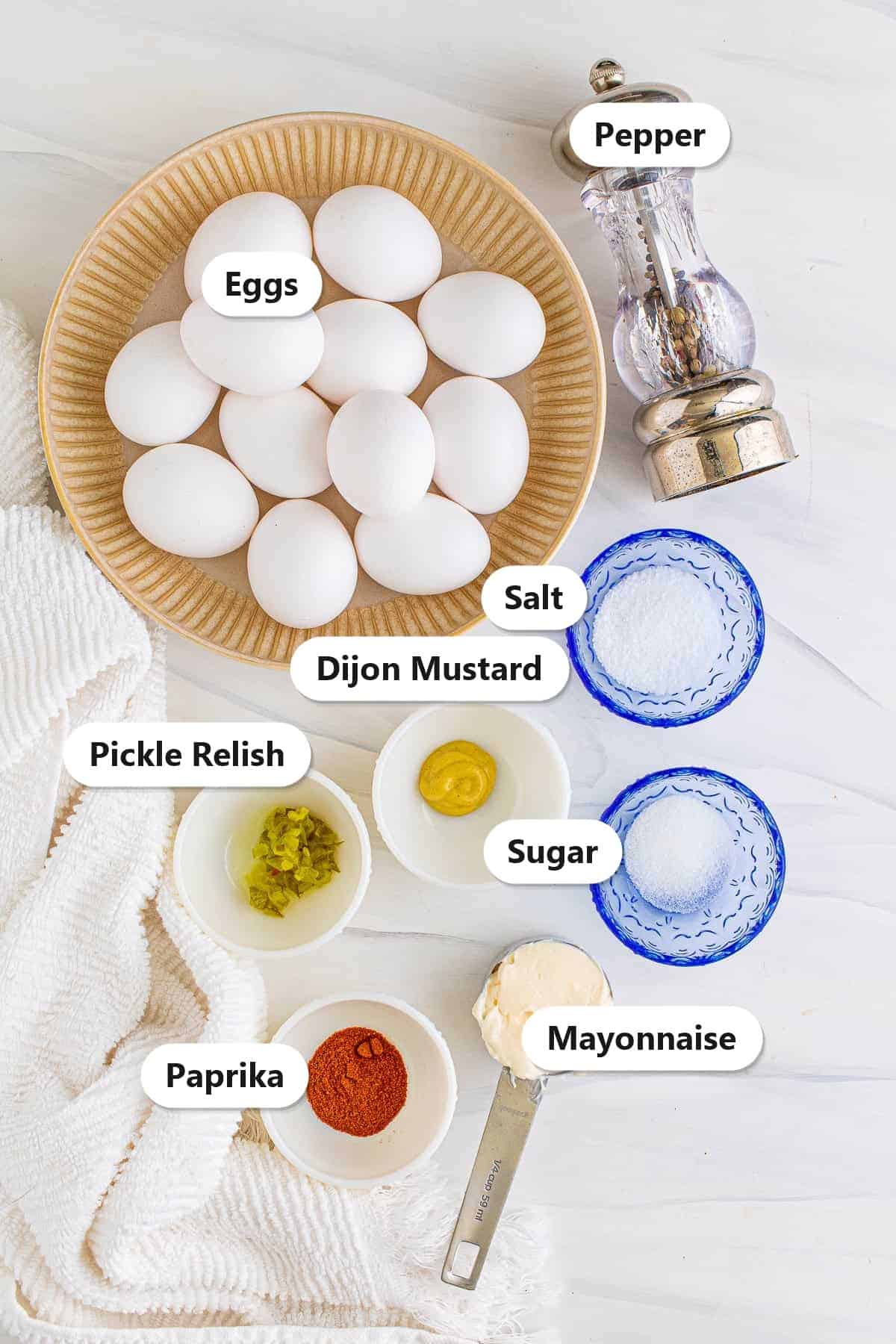 Labeled ingredients for deviled eggs including eggs, mayonnaise, pickle relish, dijon mustard, paprika, salt, sugar, and pepper.