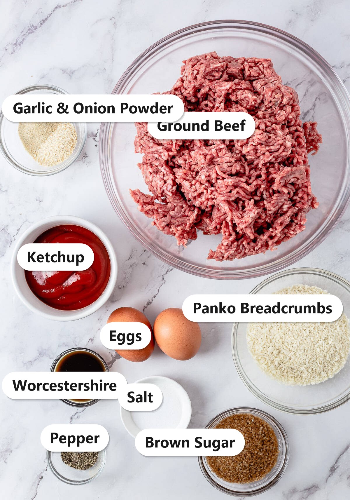 Labeled ingredients for easy meatloaf including ground beef, panko breadcrumbs, ketchup, eggs, brown sugar, Worcestershire, garlic and onion powder, salt, and pepper.