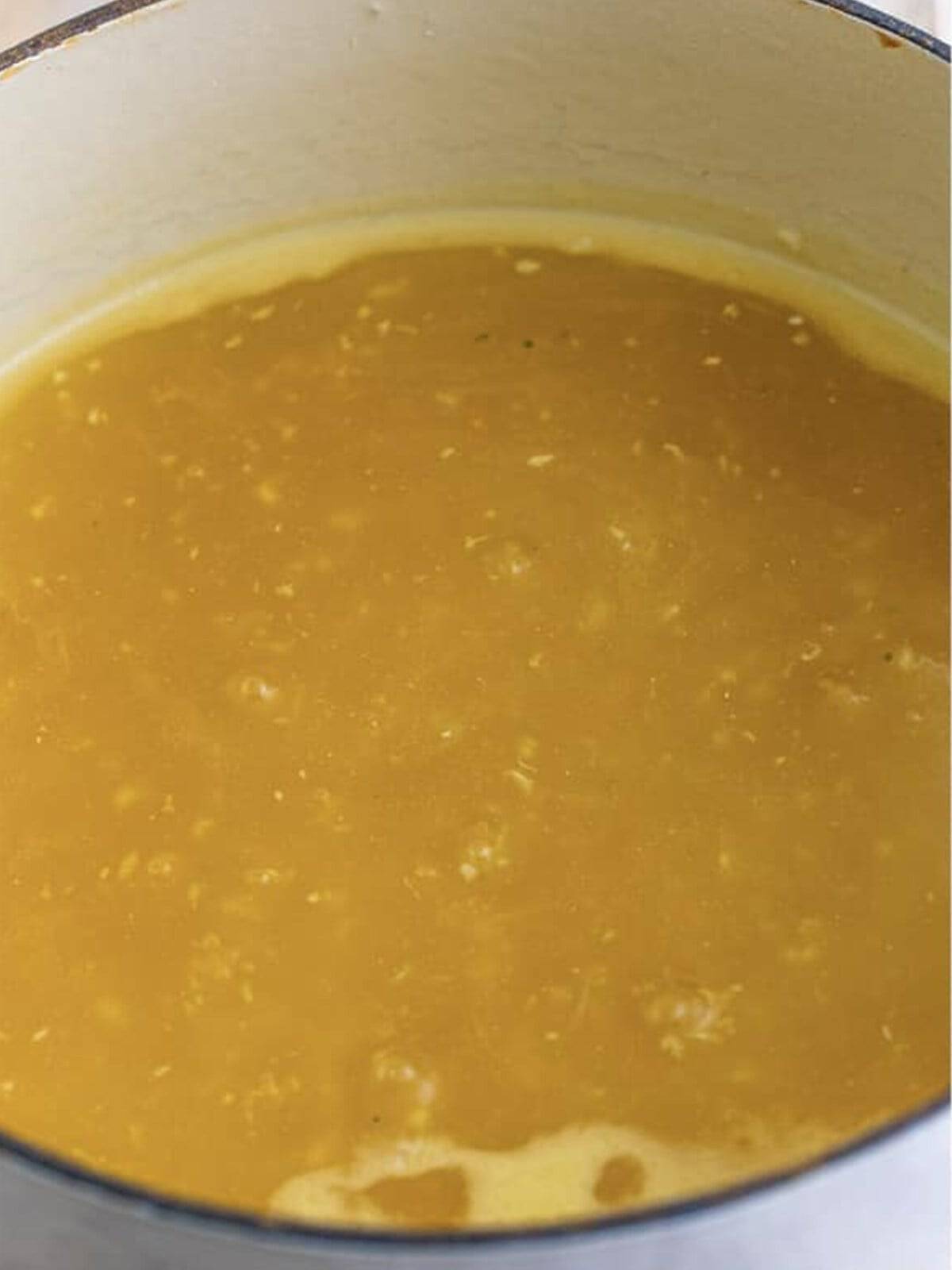 Chicken broth thickened with a cornstarch slurry in a pot.