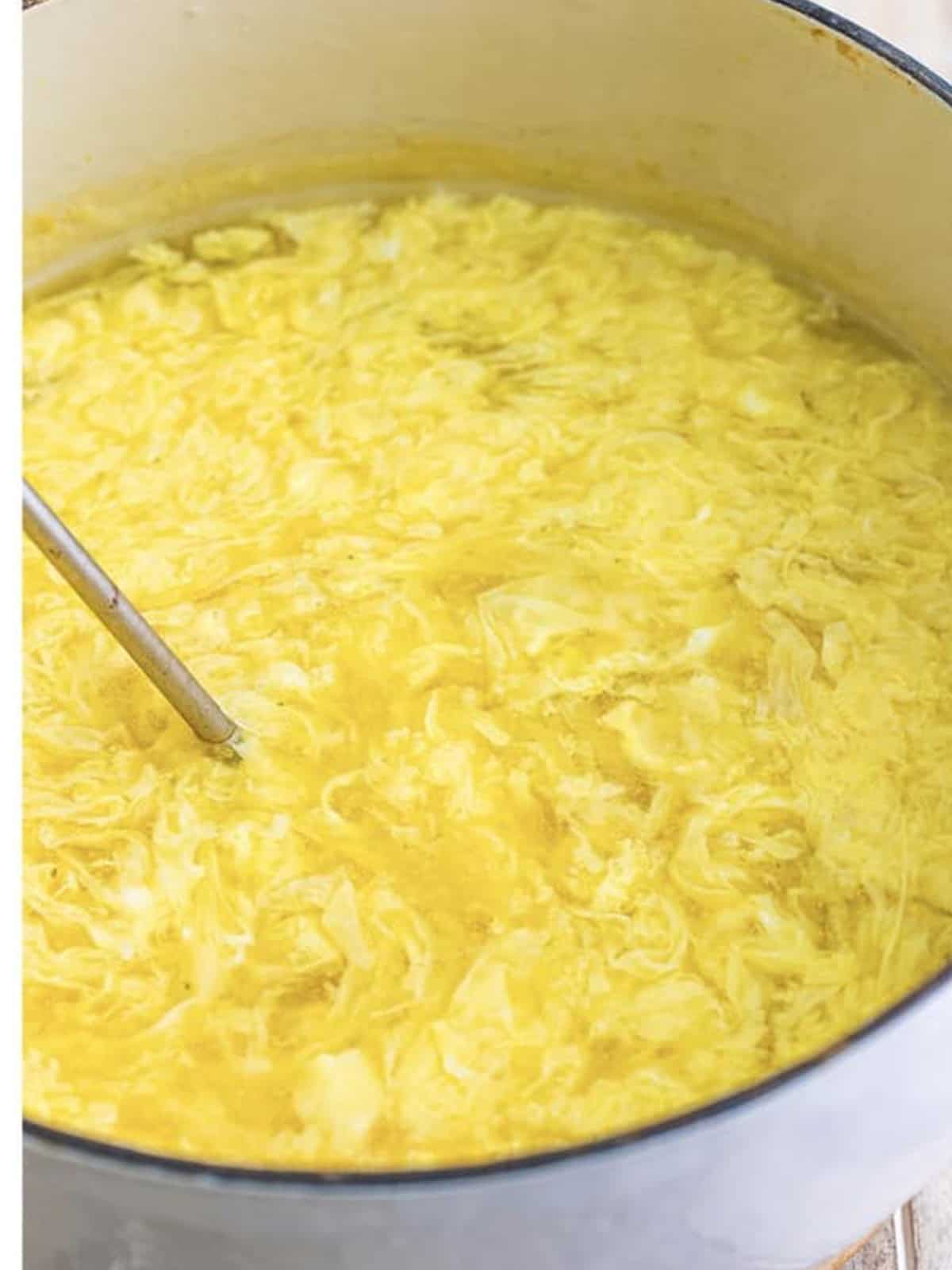 Beaten eggs streamed into broth forming silky egg ribbons for egg drop soup.