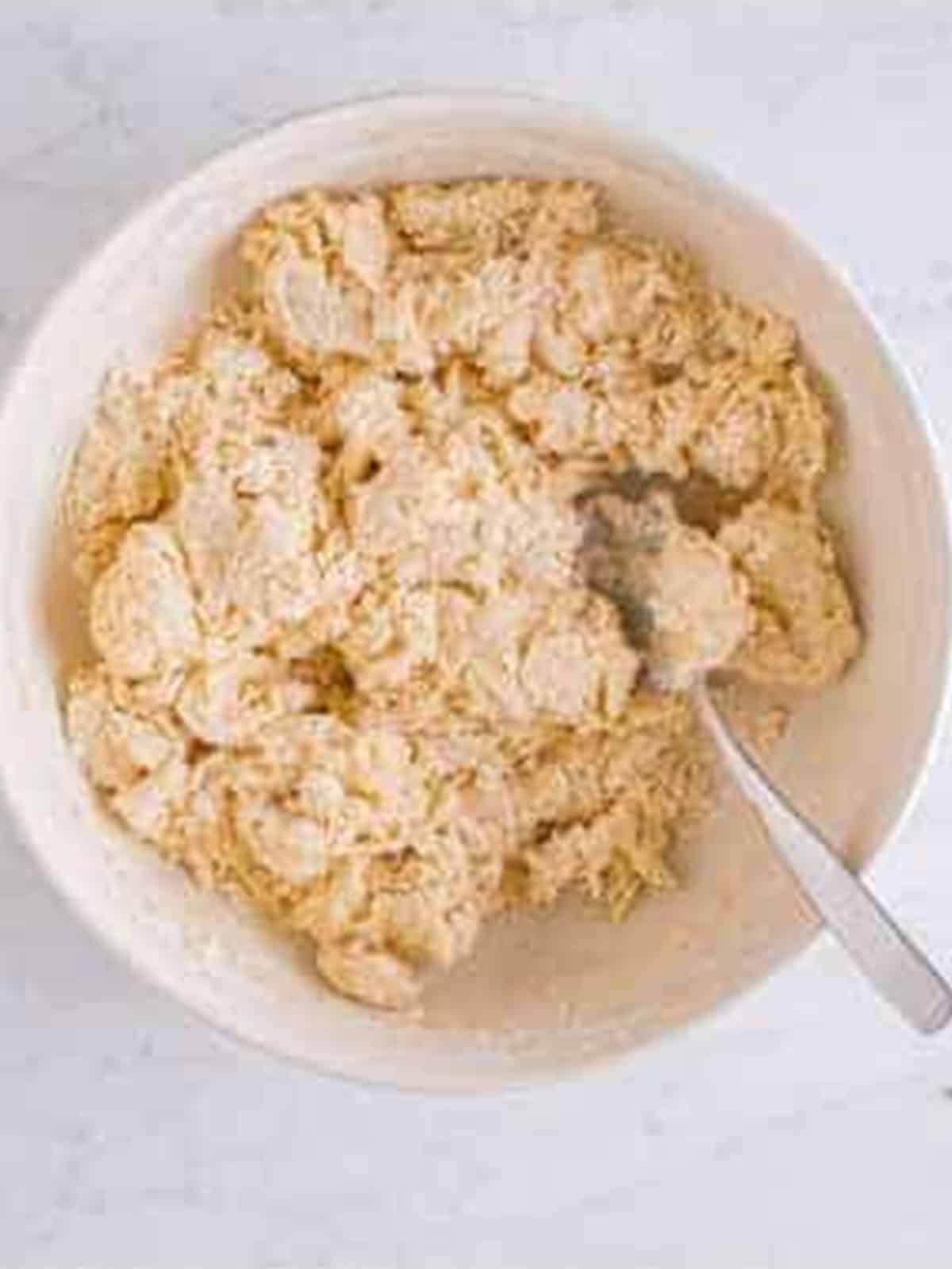 Shaggy English muffin dough coming together in a bowl.
