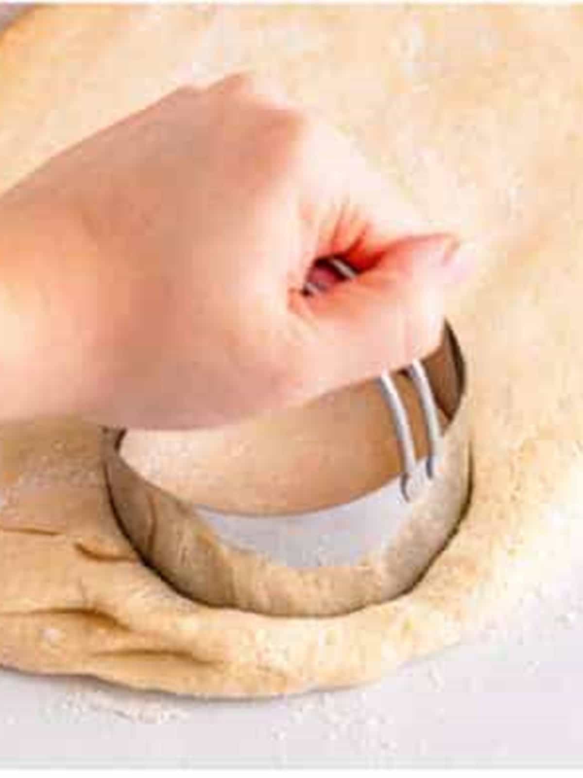 Cutting rounds of dough with a biscuit cutter for English muffins.
