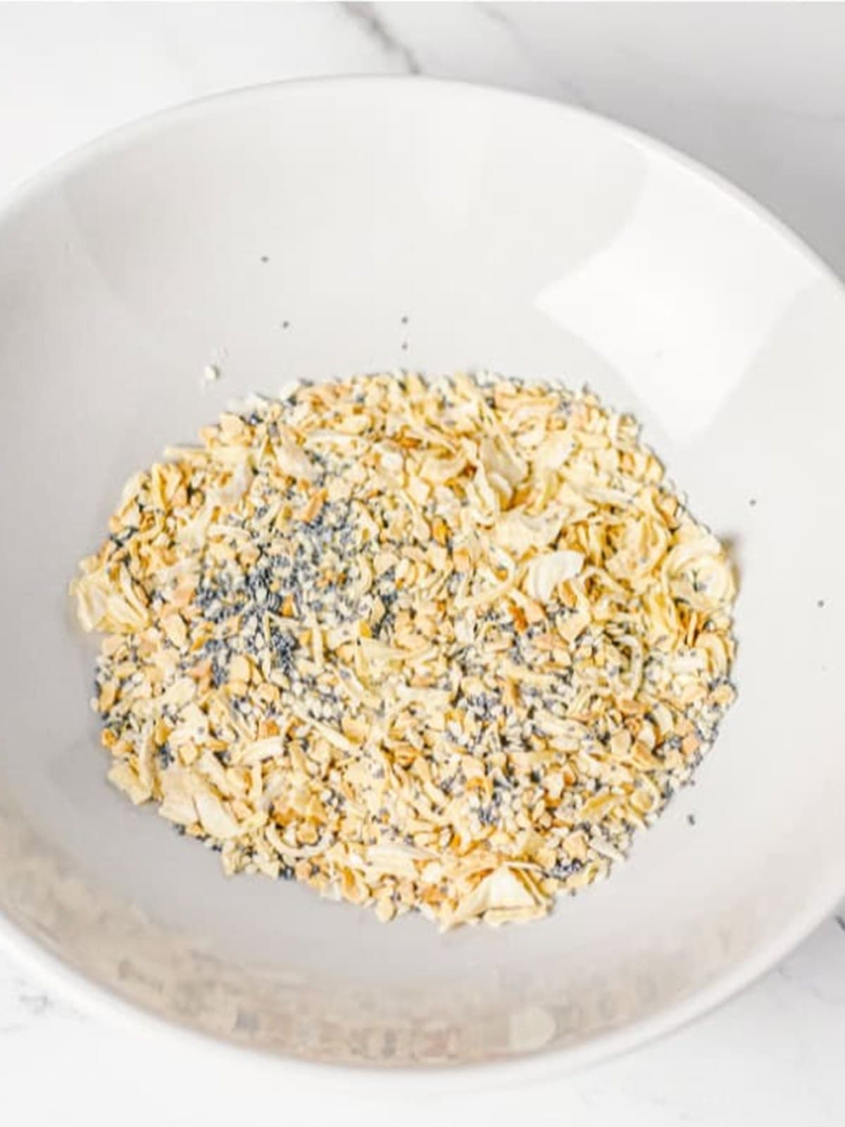 Poppy seeds, sesame seeds, dried garlic, onion flakes, and salt mixed in a bowl for the everything bagel seasoning.